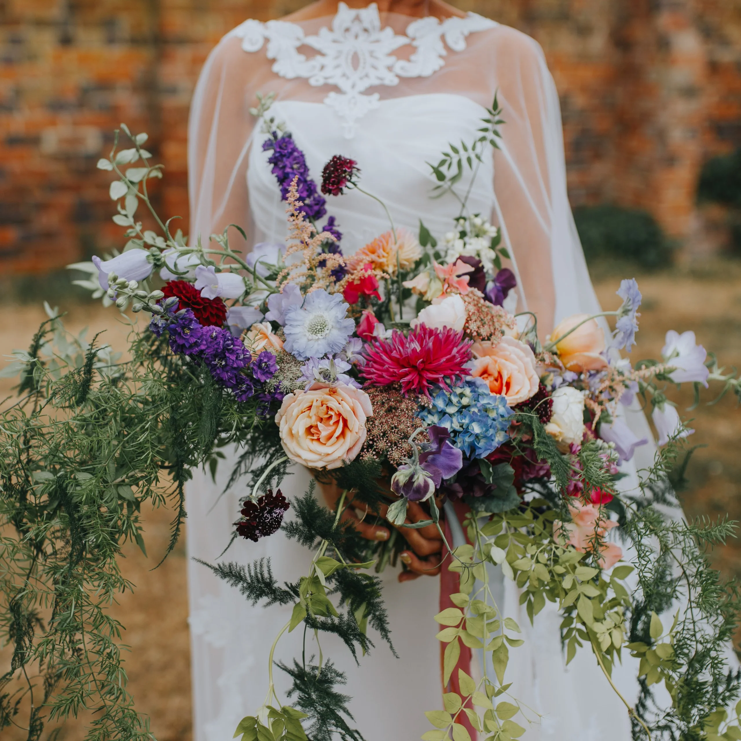 a bride holding a bouquet of flowers made by catkin at doddington hall