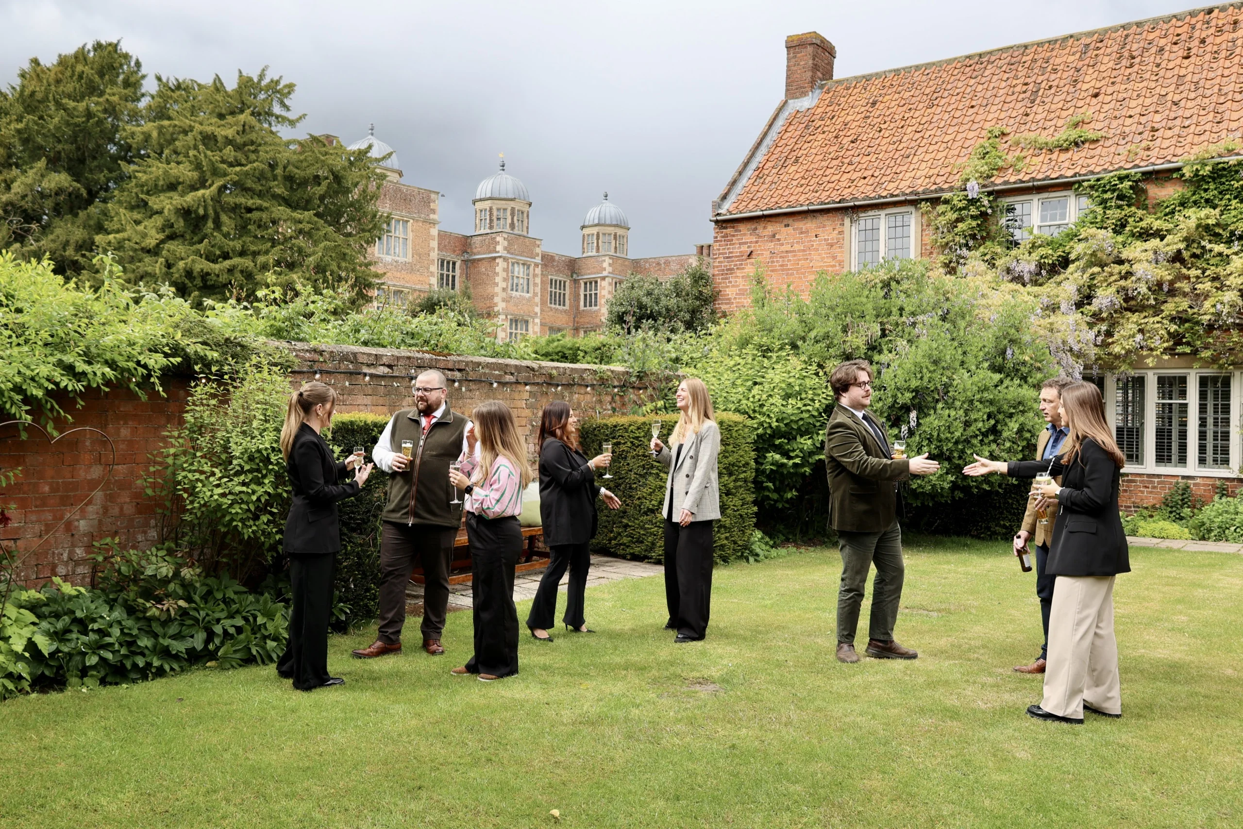 a group of professionals speaking on the lawn at doddington estate