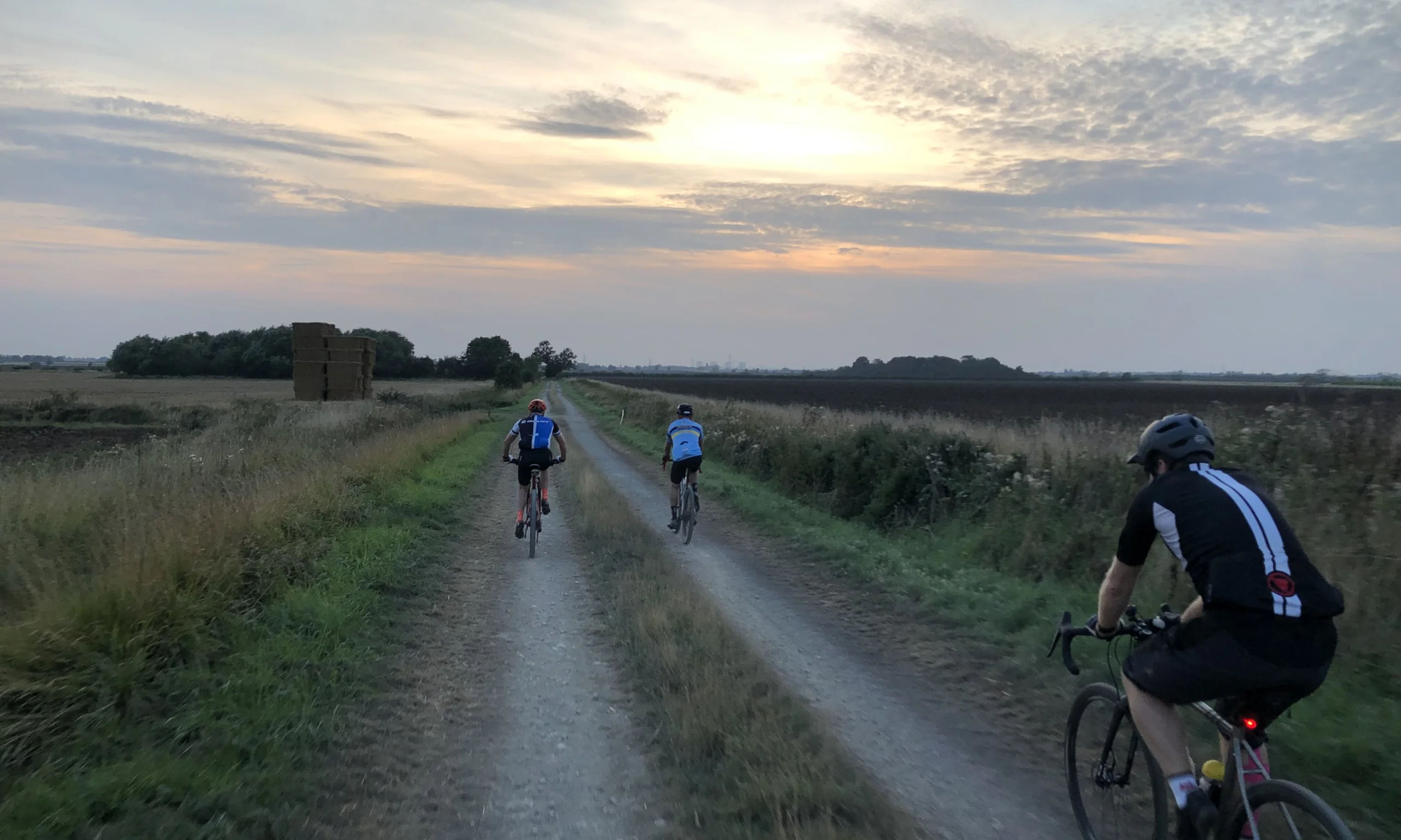 a group of cyclists on a cycling track at sunset