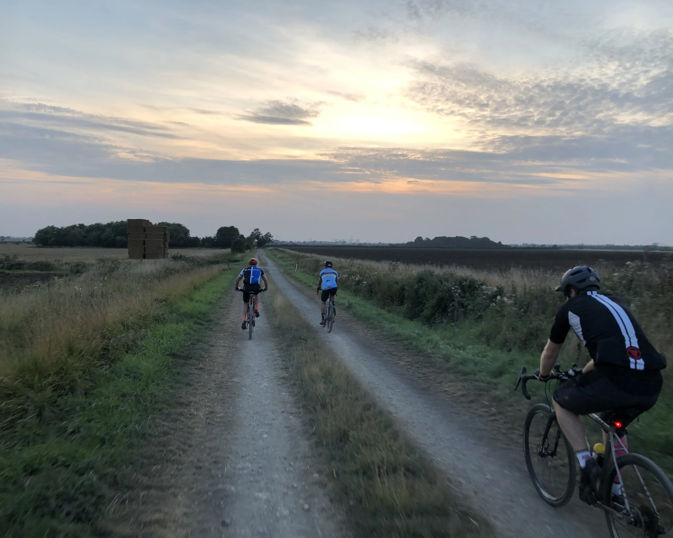 a group of cyclists on a cycling track at sunset