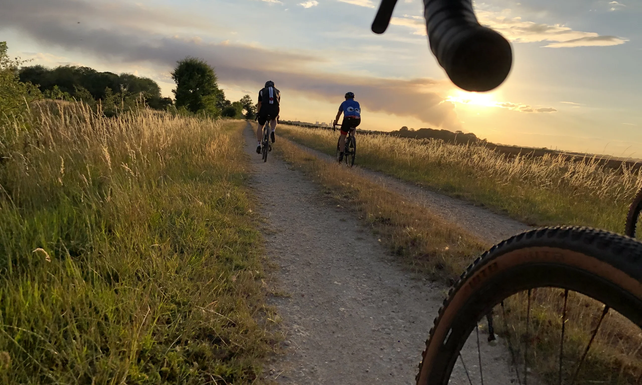 a group of cyclists on a cycling track at sunset