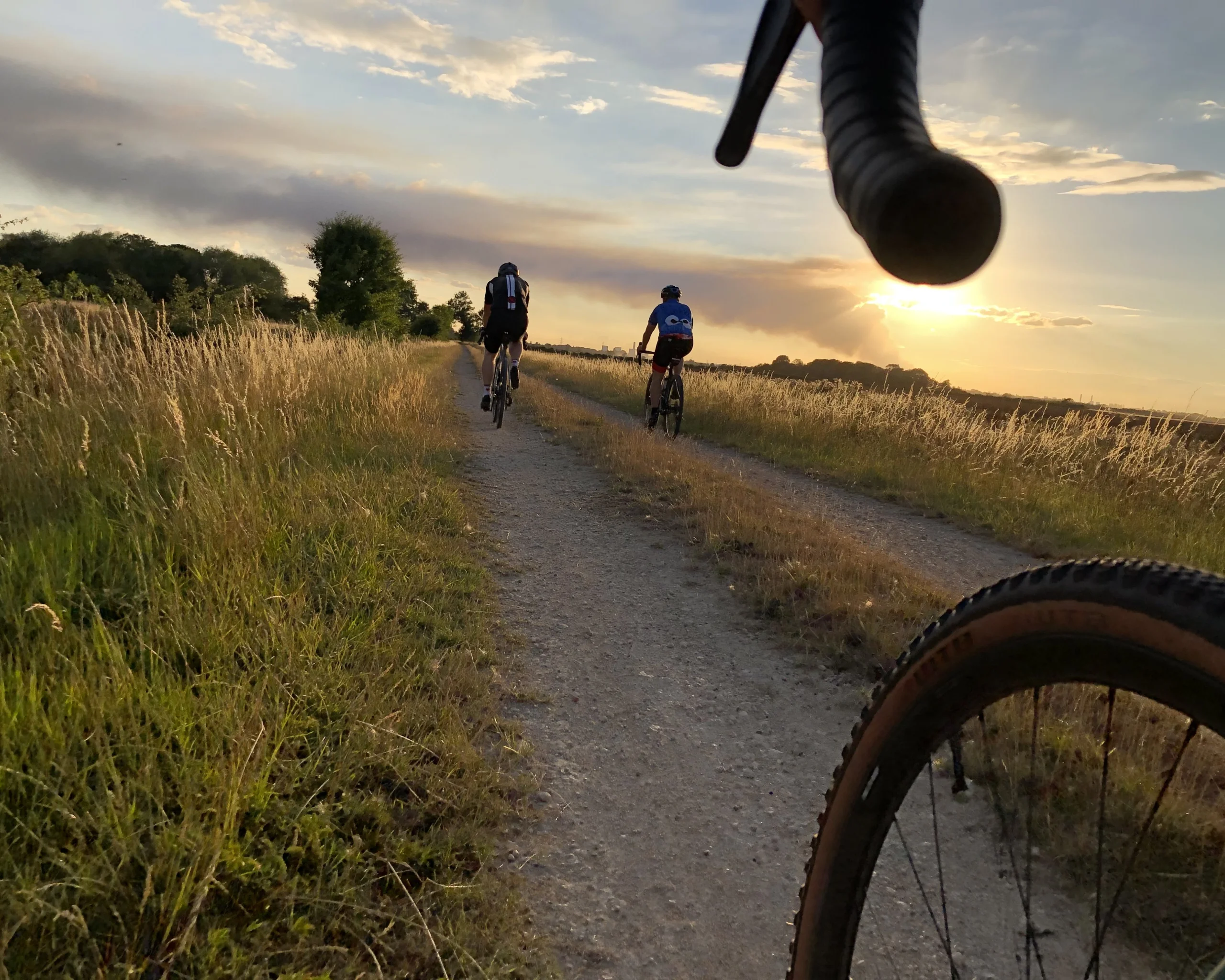 a group of cyclists on a cycling track at sunset