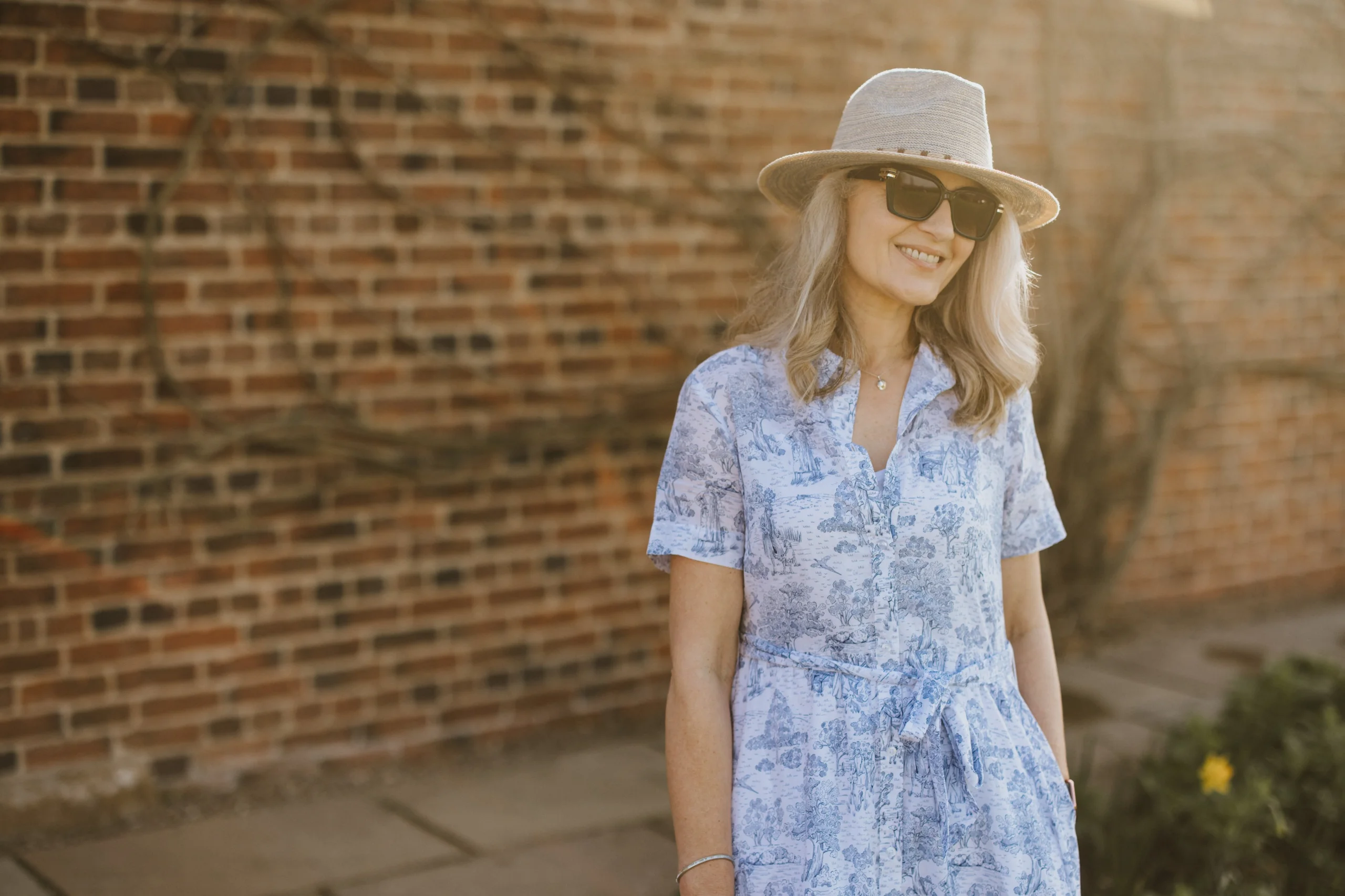 lady wearing a printed dress and straw hat doddington country clothing