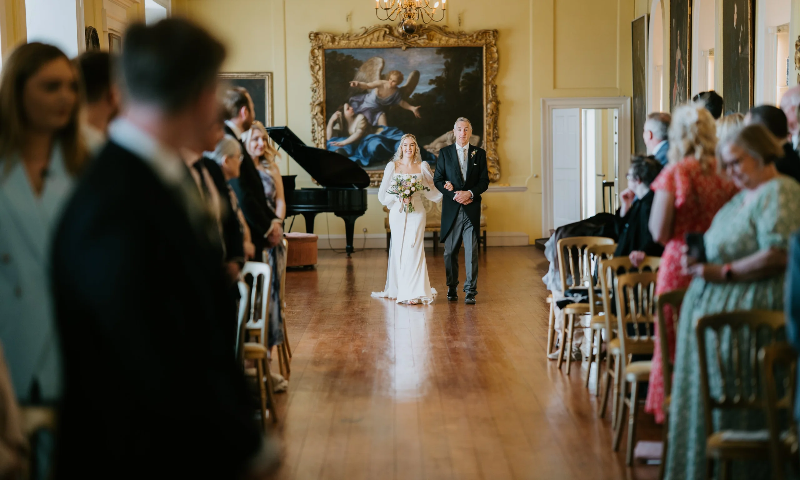 a bride and father of the bride walking in the long room at doddington hall