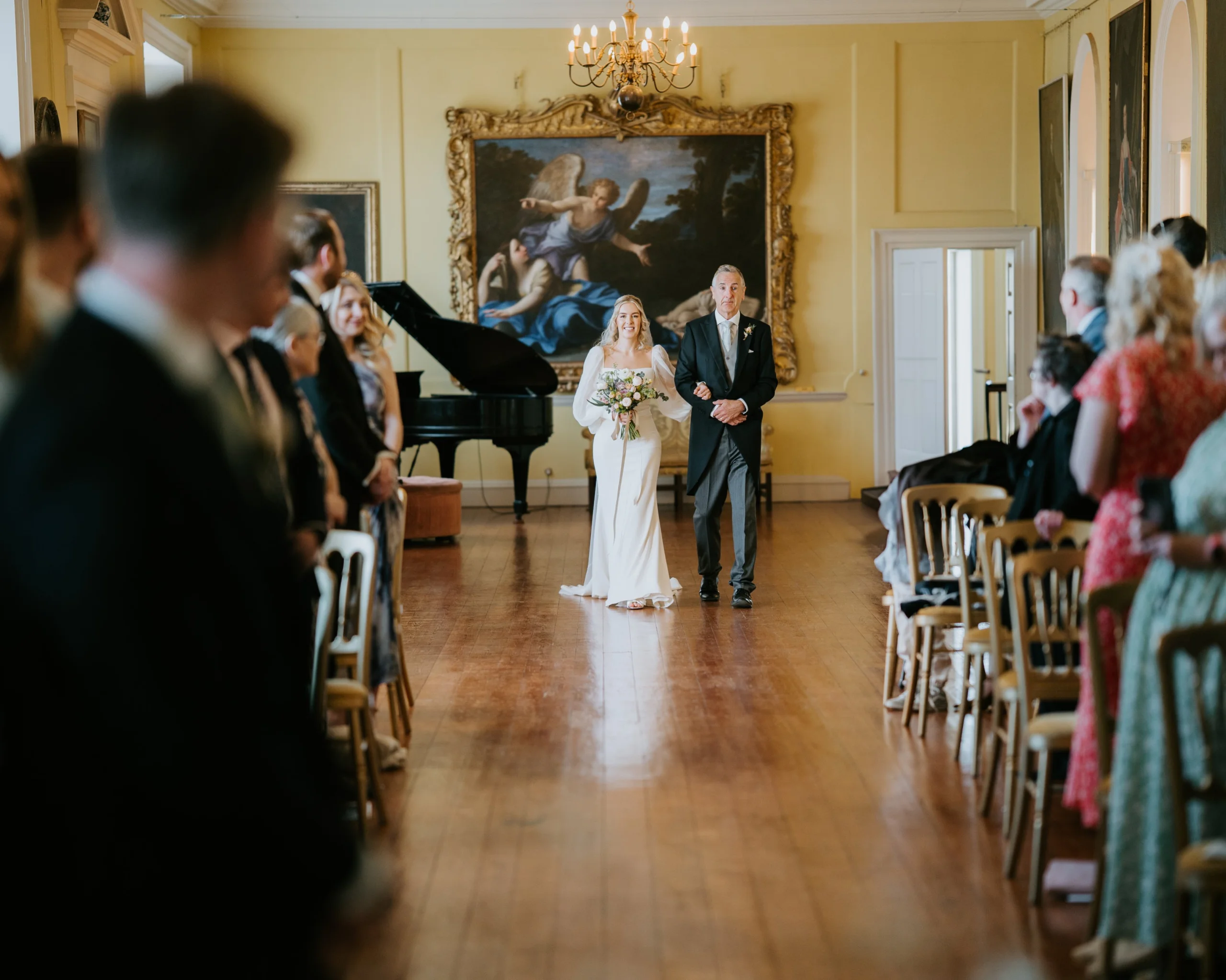 a bride and father of the bride walking in the long room at doddington hall