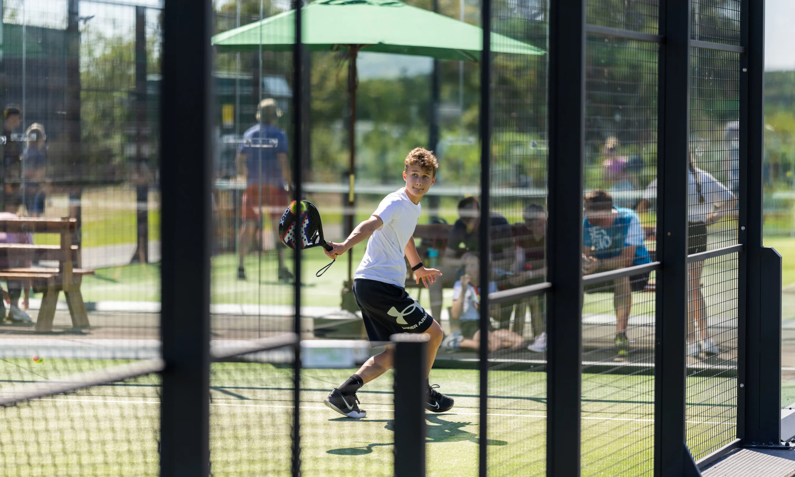 a boy playing padel at doddington hall padel courts