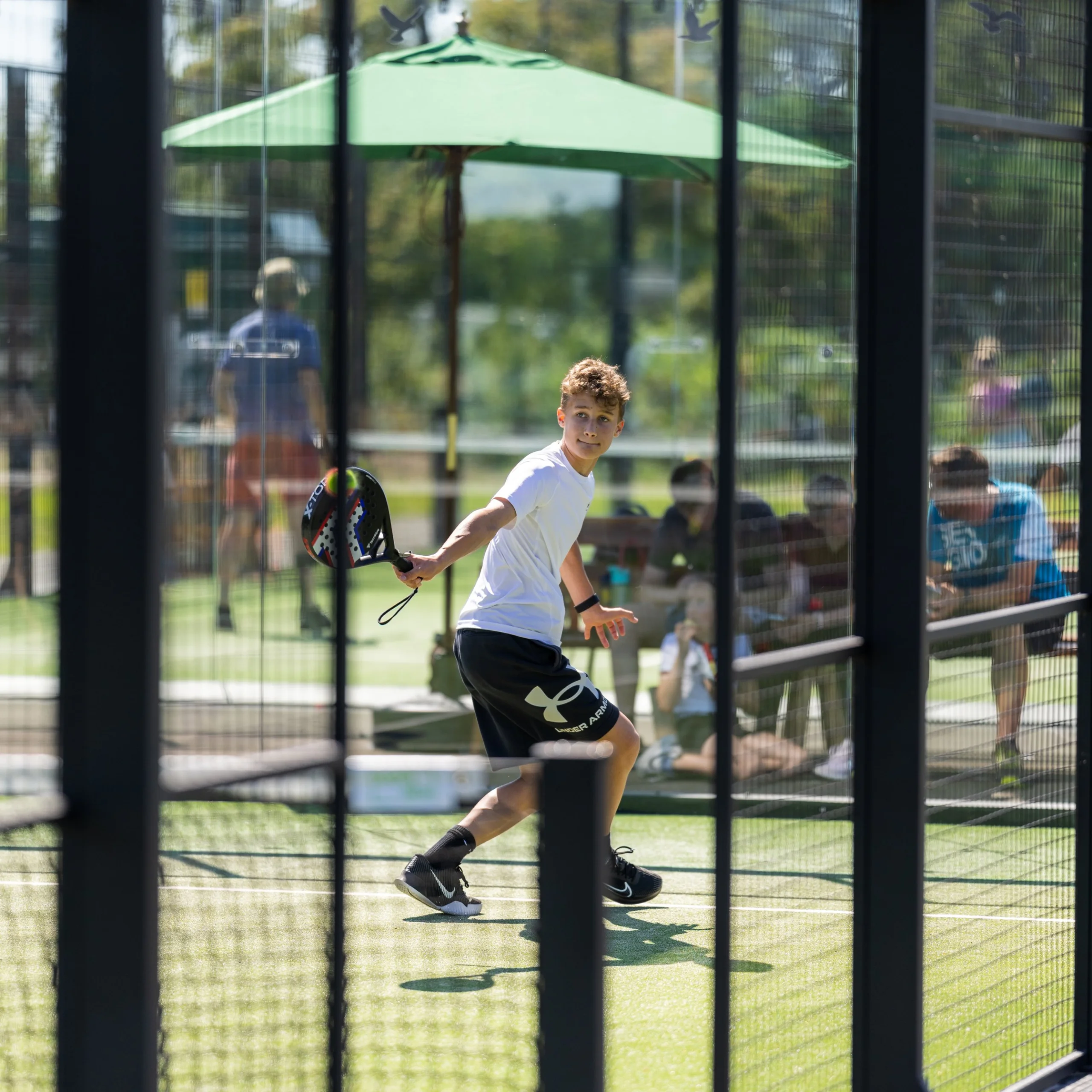 a boy playing padel at doddington hall padel courts