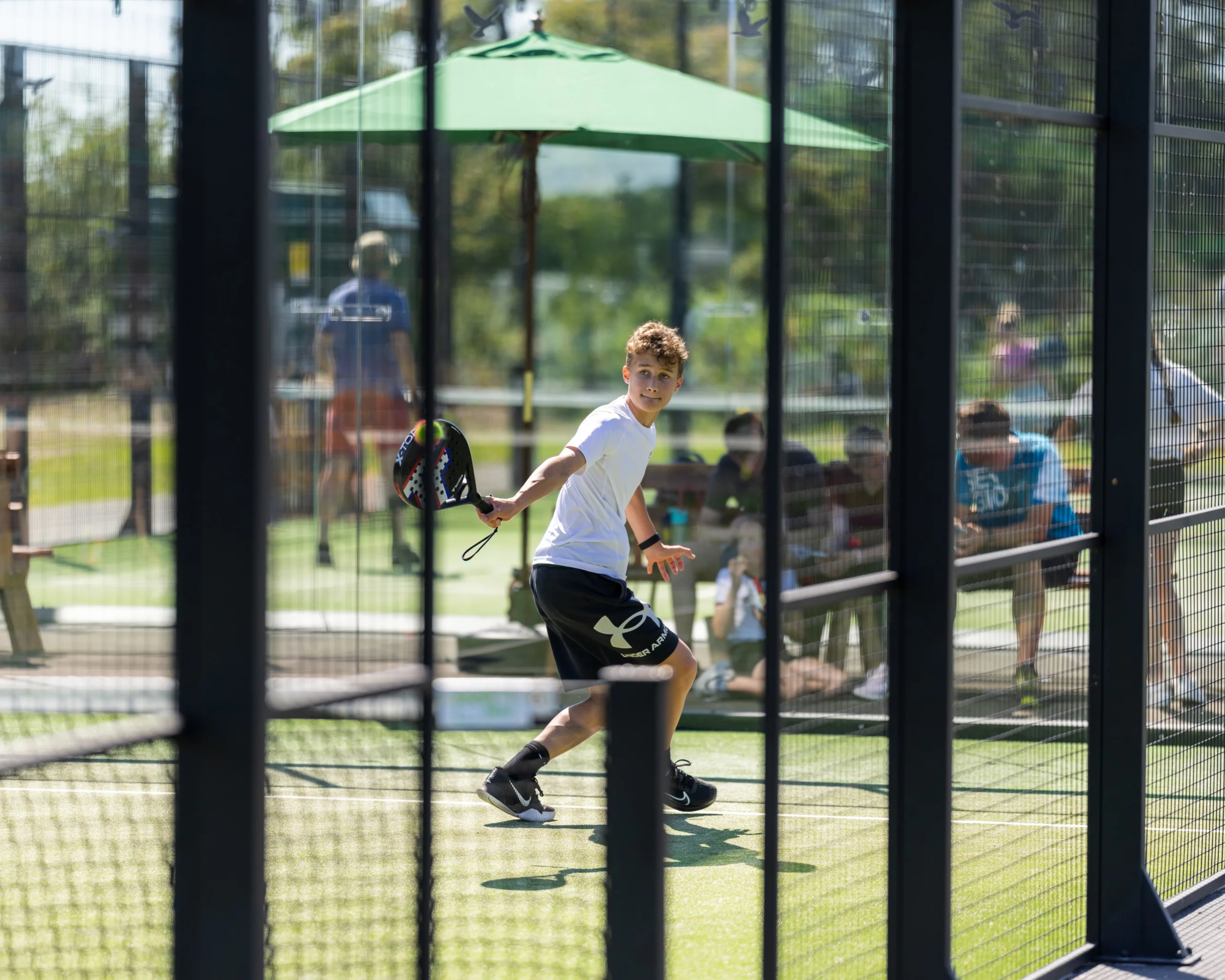 a boy playing padel at doddington hall padel courts