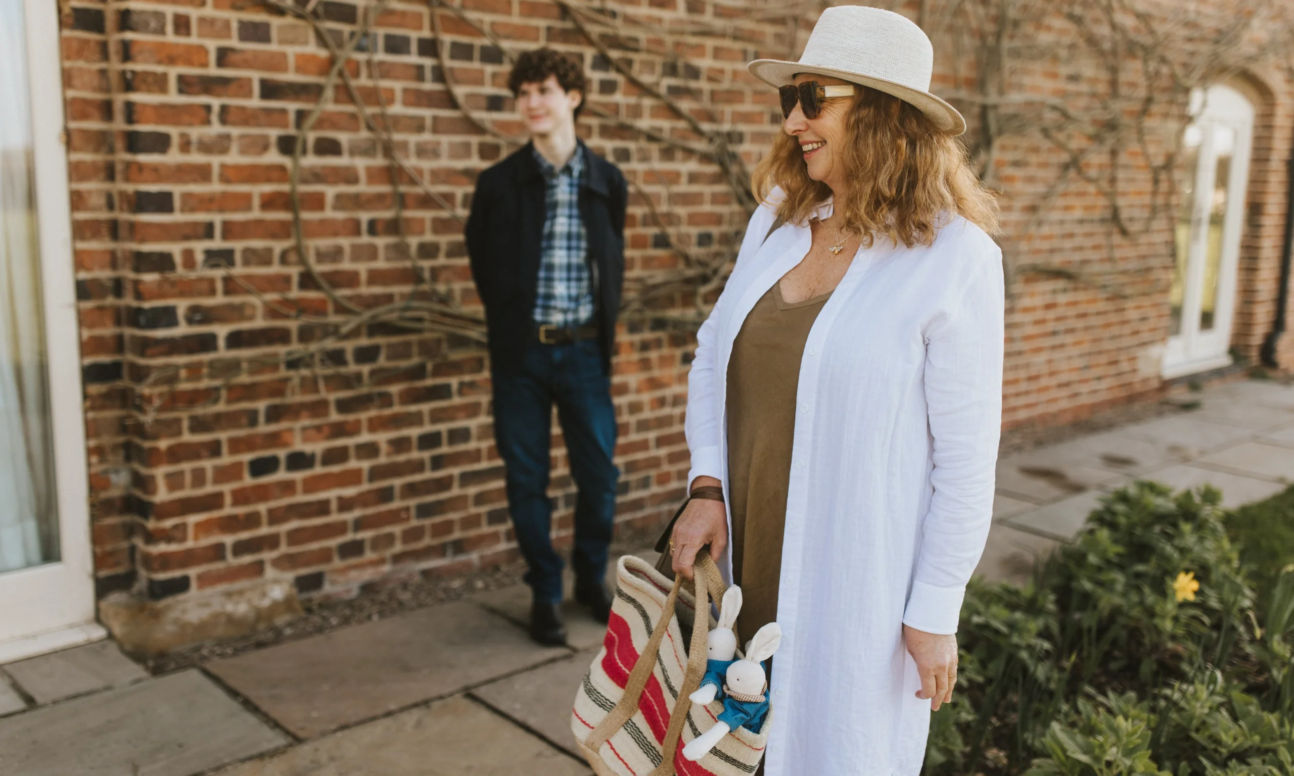 a lady in a white linen jacket with a hat at doddington hall