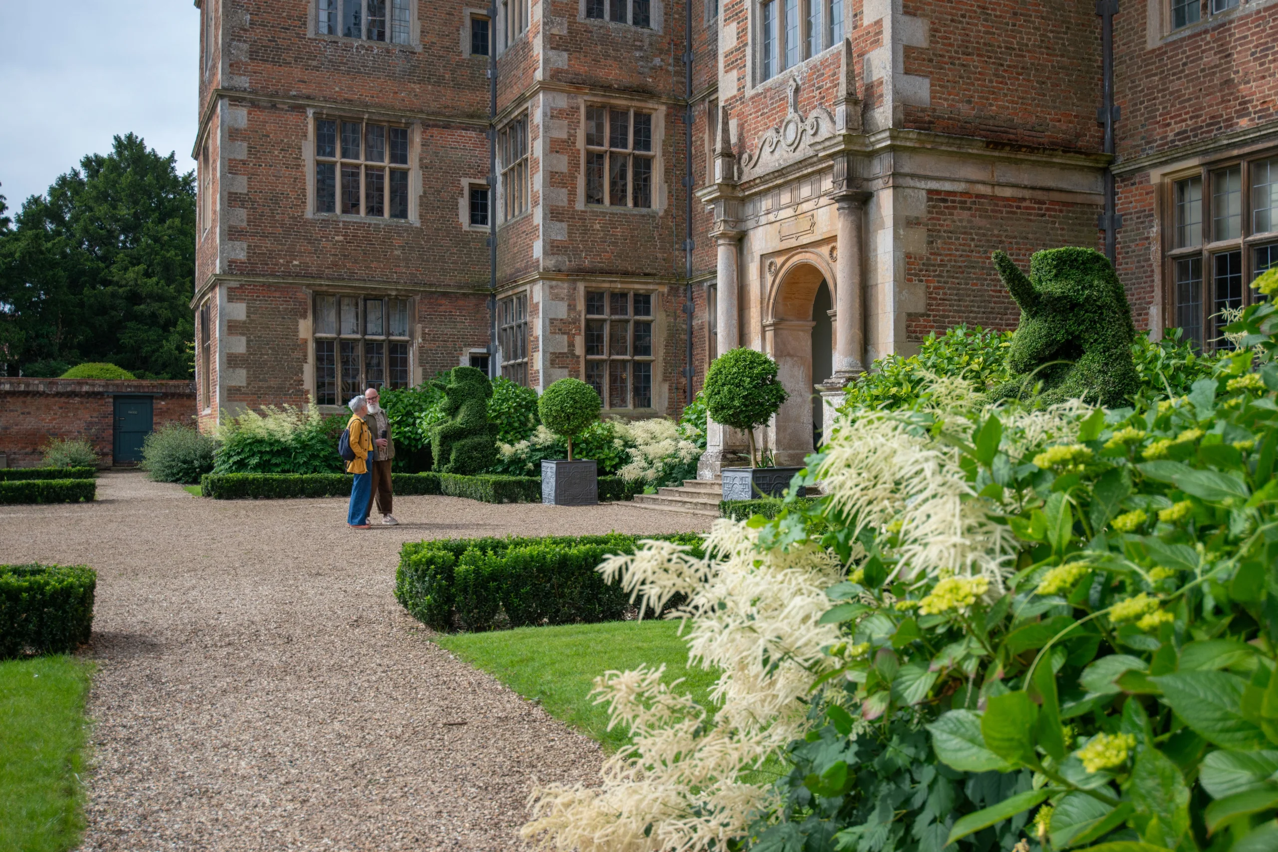 a couple admiring the east front of doddington hall