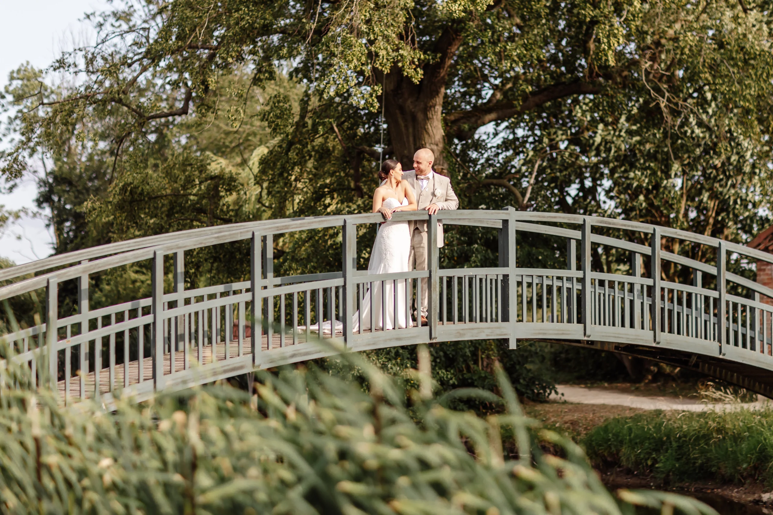 bride and groom at the fishpond bridge at doddington hall estate