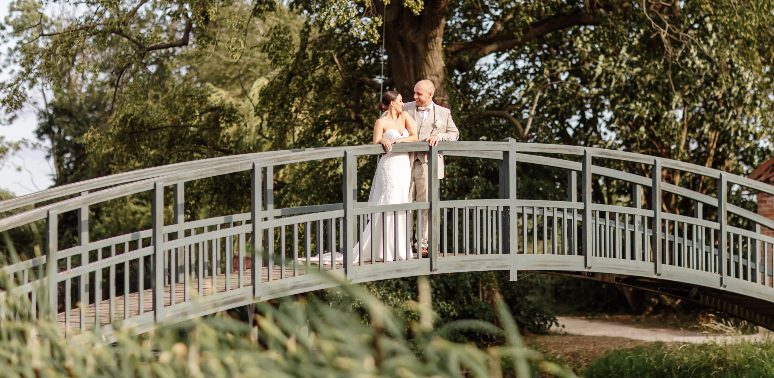 bride and groom at the fishpond bridge at doddington hall estate