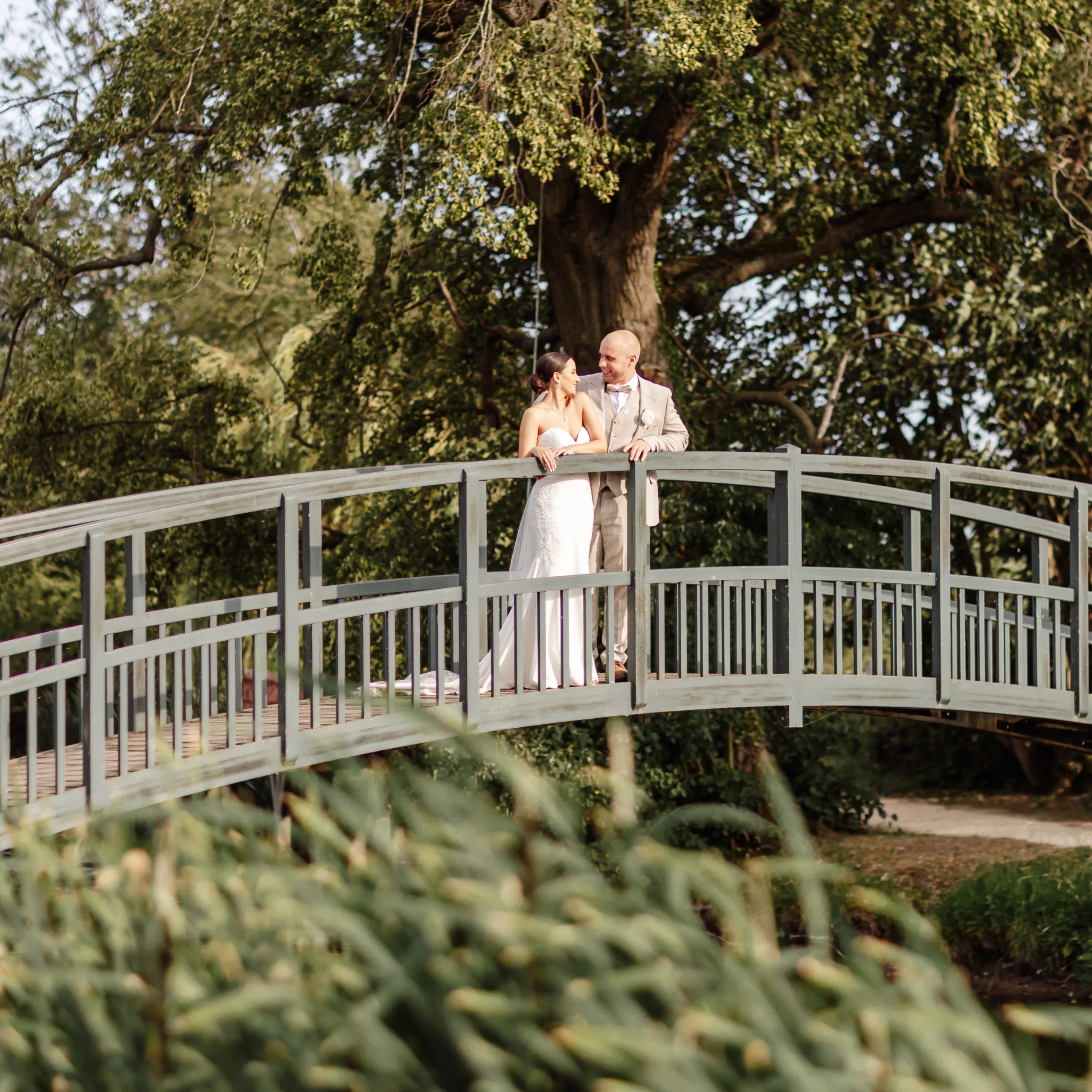 bride and groom at the fishpond bridge at doddington hall estate