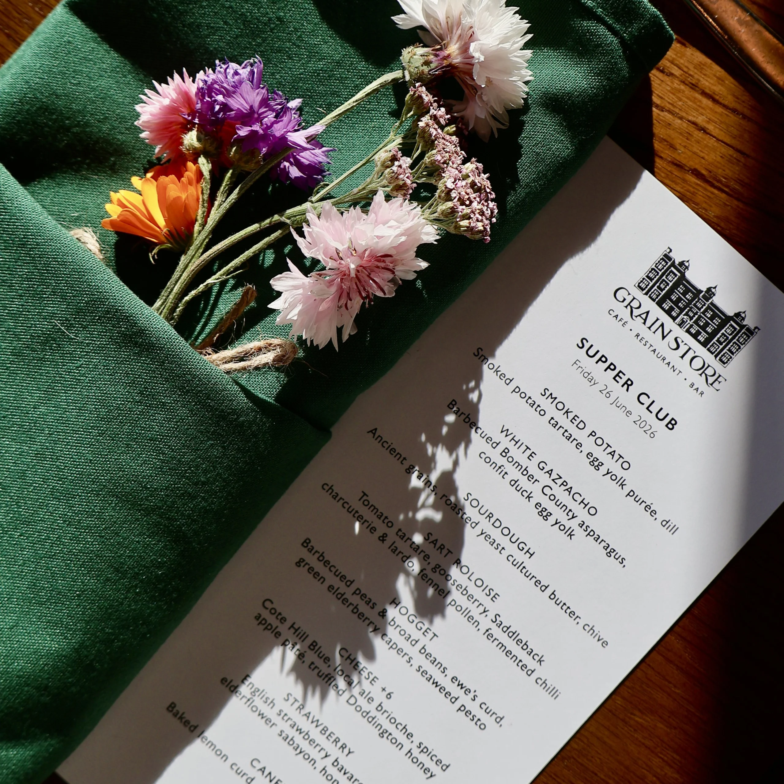 An aerial view of a menu and a napkin with flowers tucked in at doddington hall