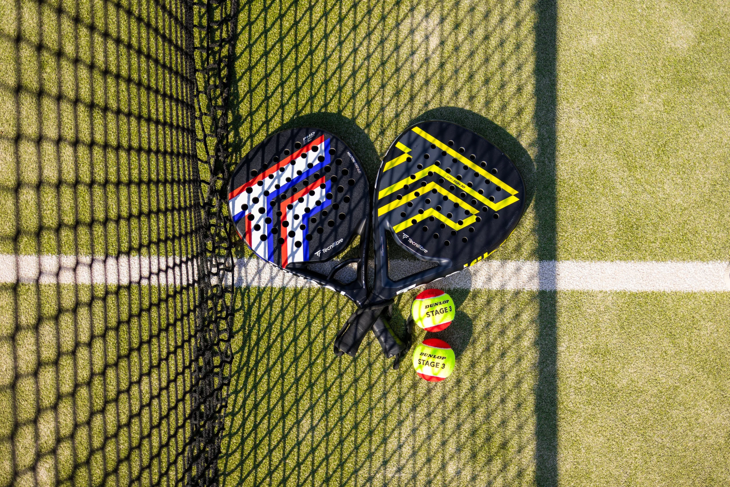 a close up of two padel rackets and balls next to a padel net at doddington hall