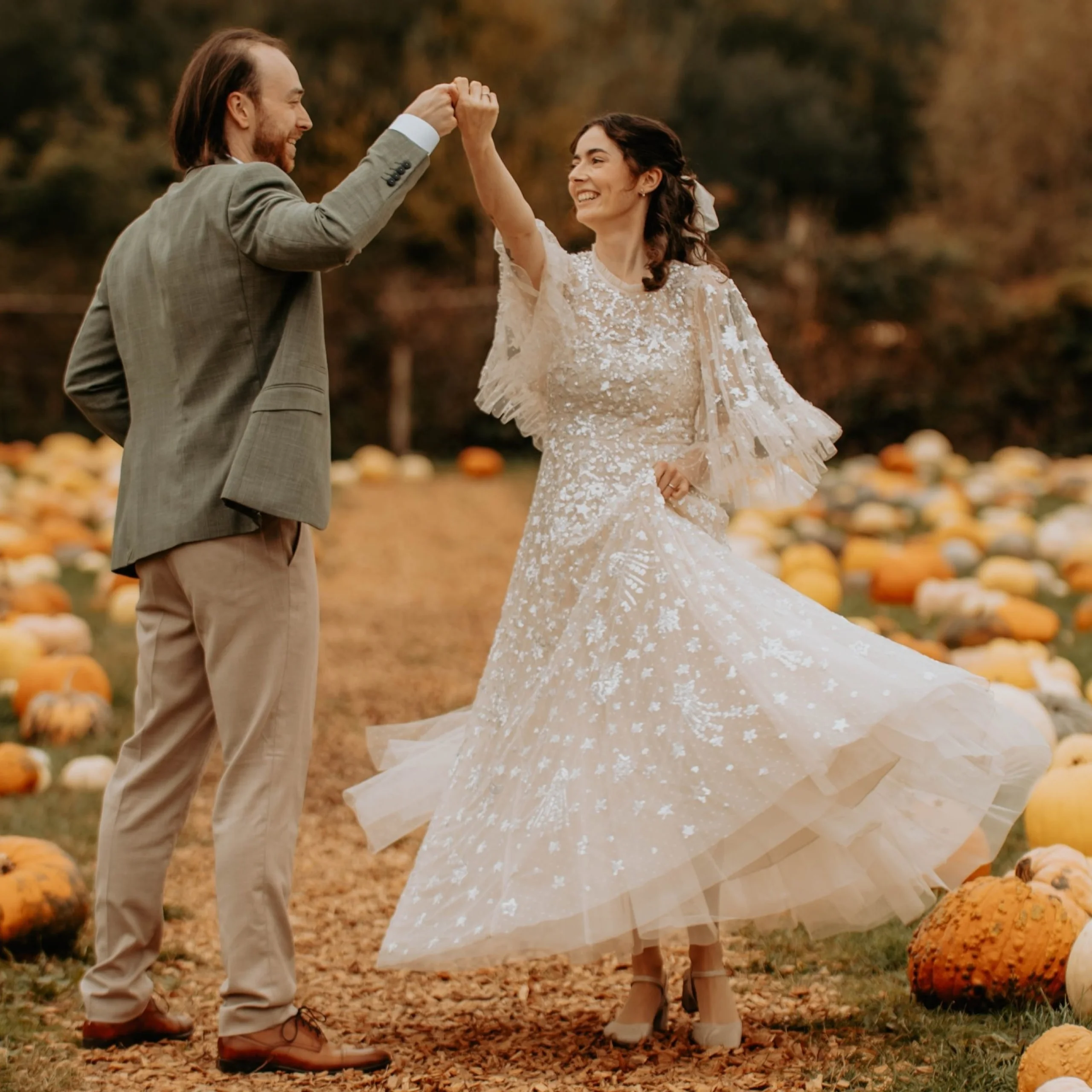 A newly married couple dance in a pumpkin patch