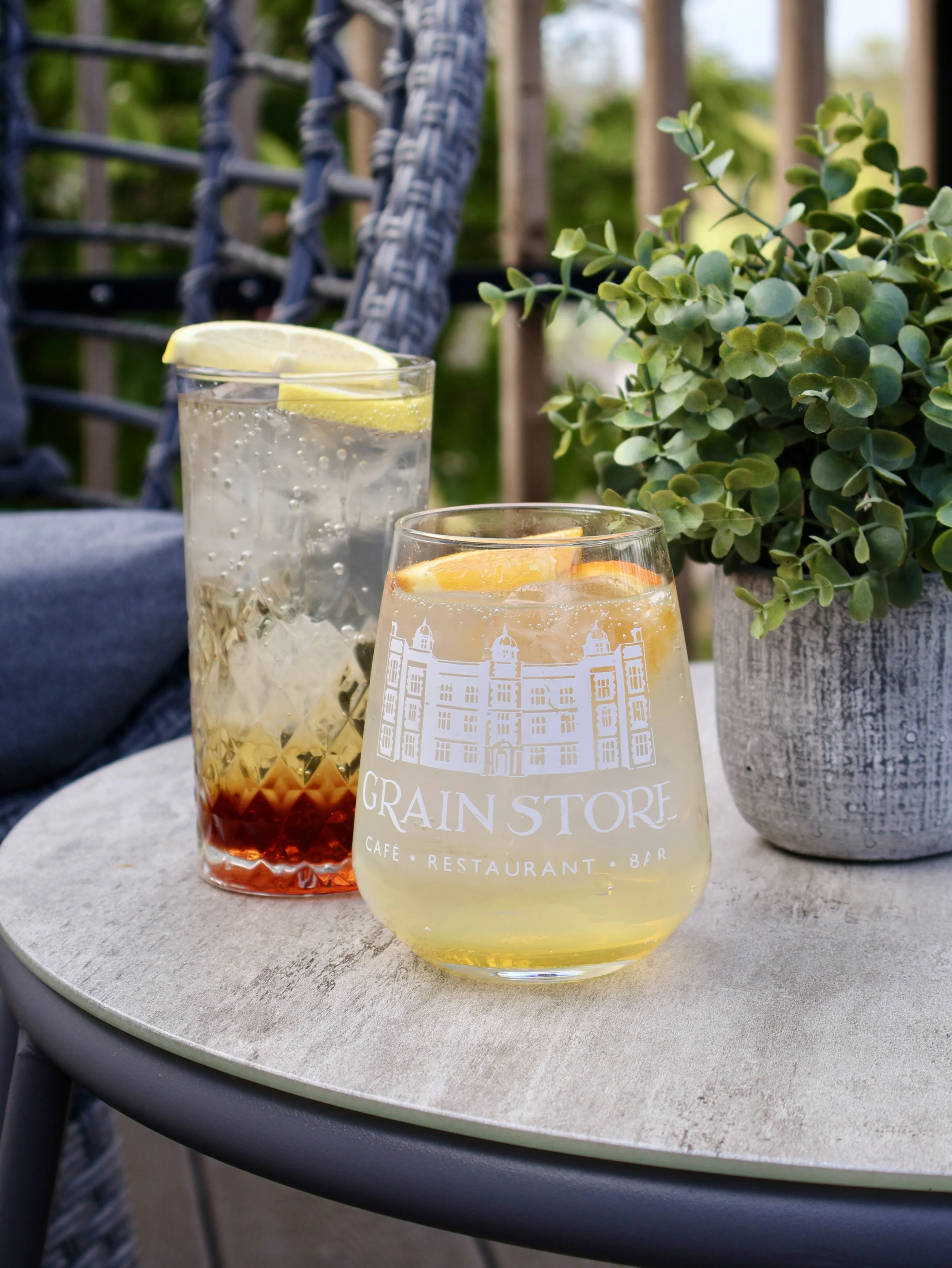 Two cold summer sparkling drinks on an outdoor table