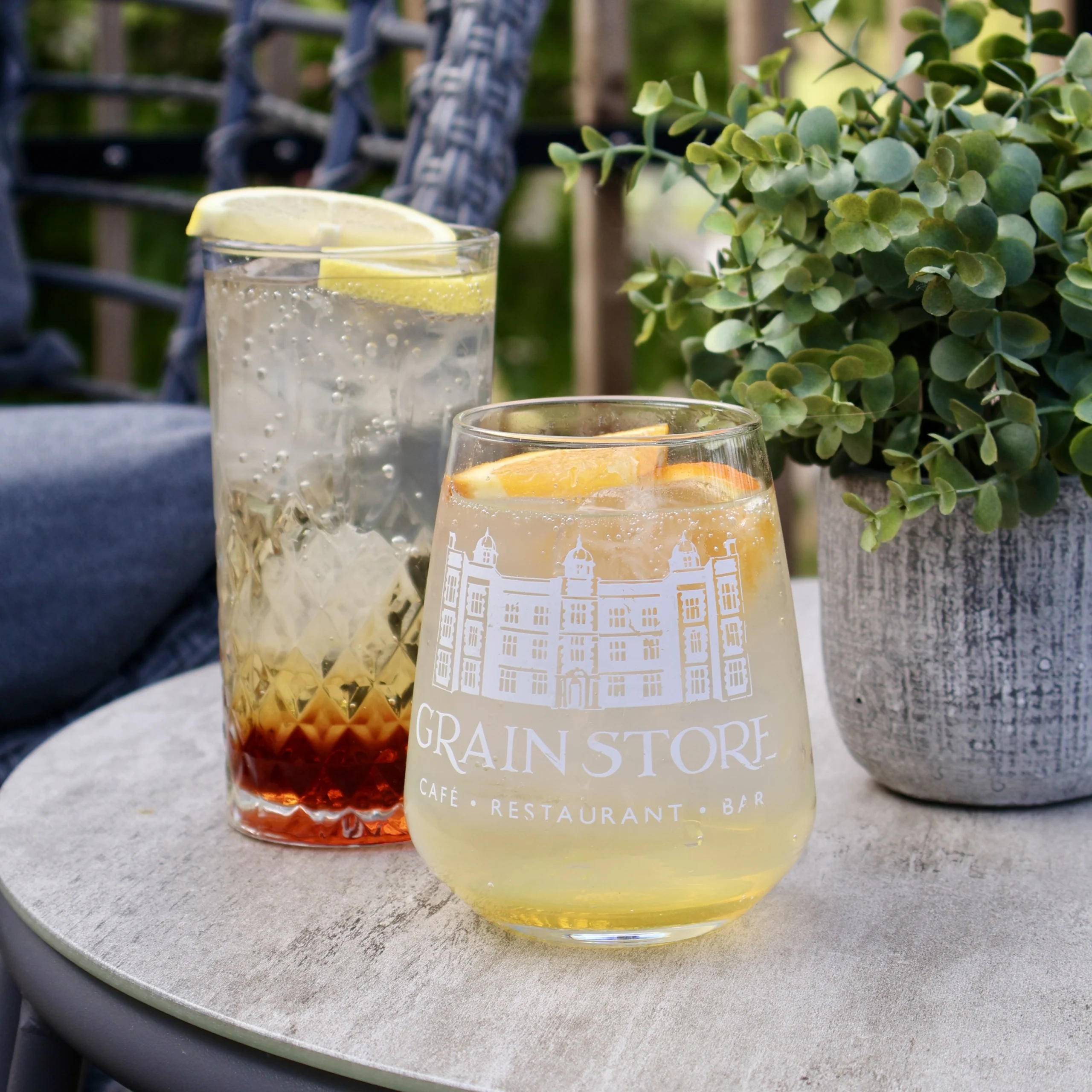 Two cold summer sparkling drinks on an outdoor table