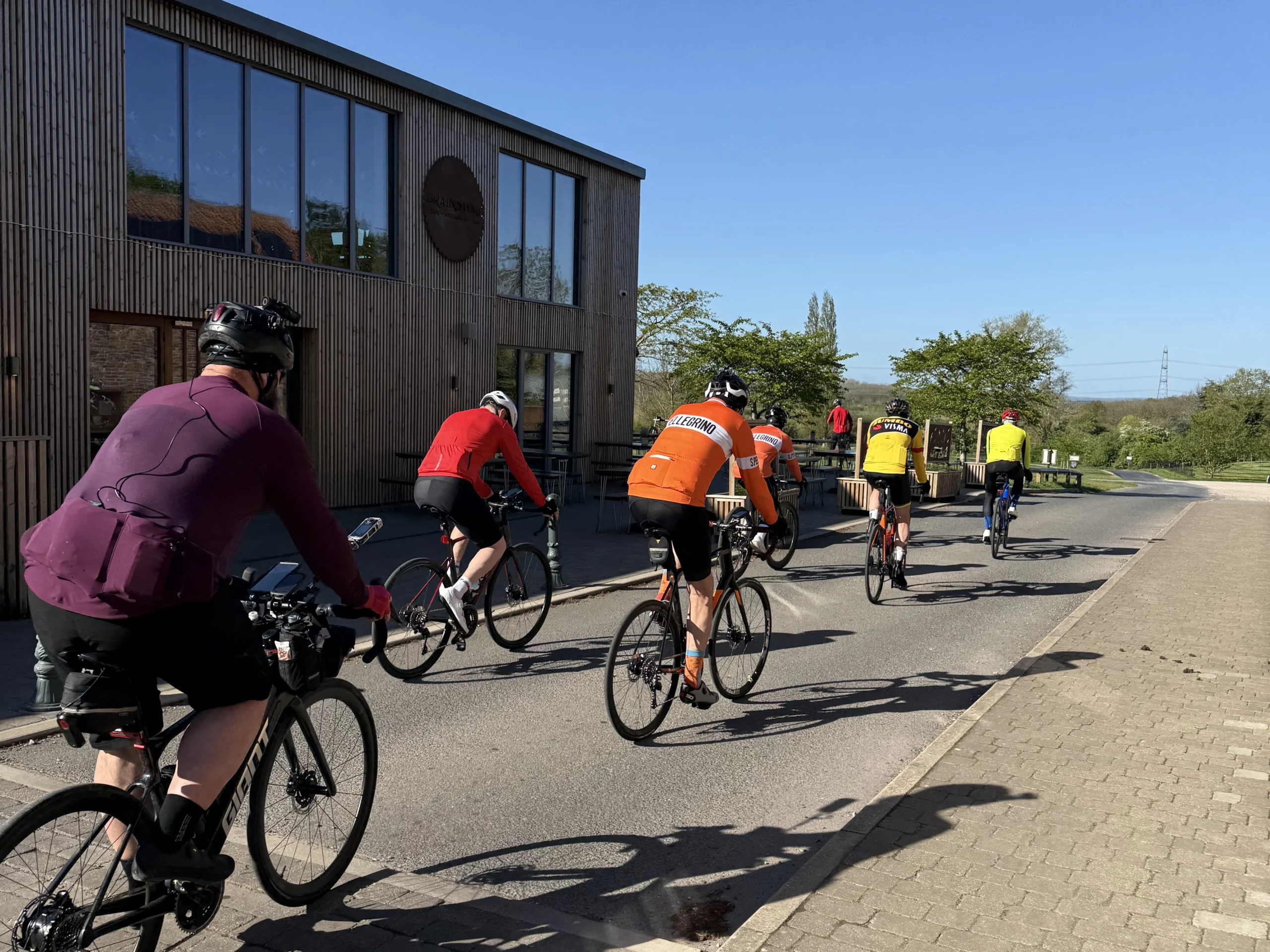 a group of cyclists passing the grain store at doddington hall