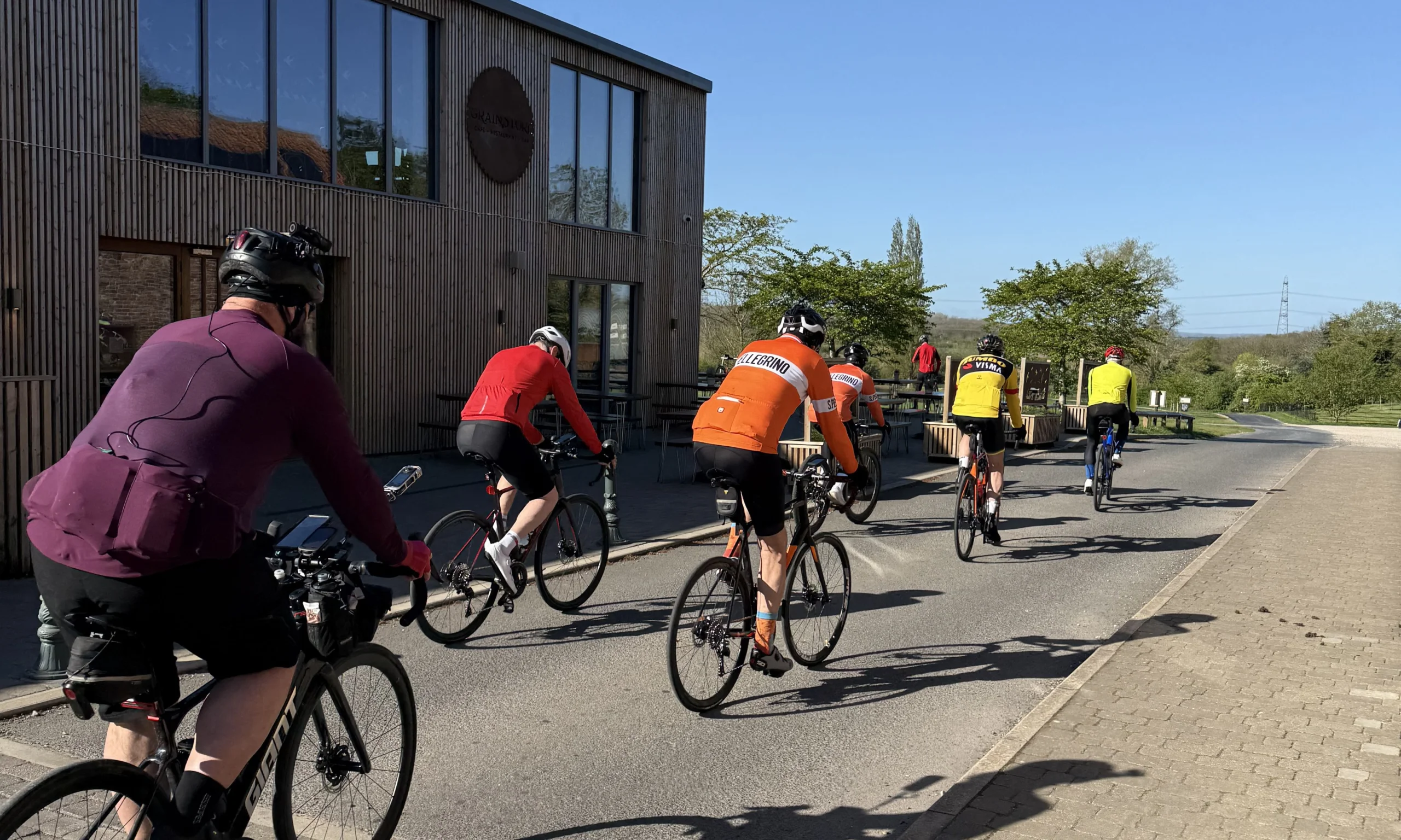 a group of cyclists passing the grain store at doddington hall