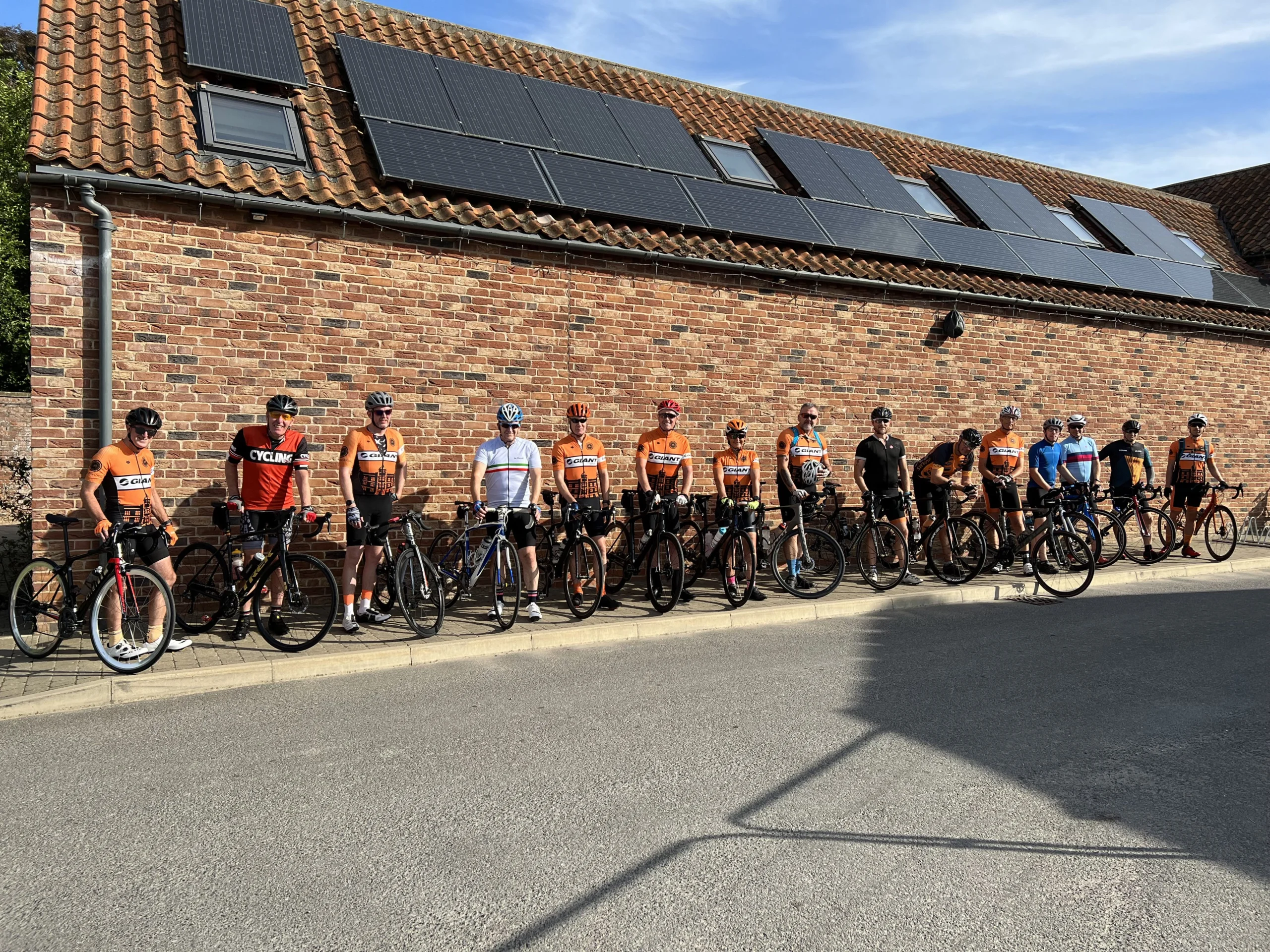 a large group of cyclists stationary opposite grain store doddington hall