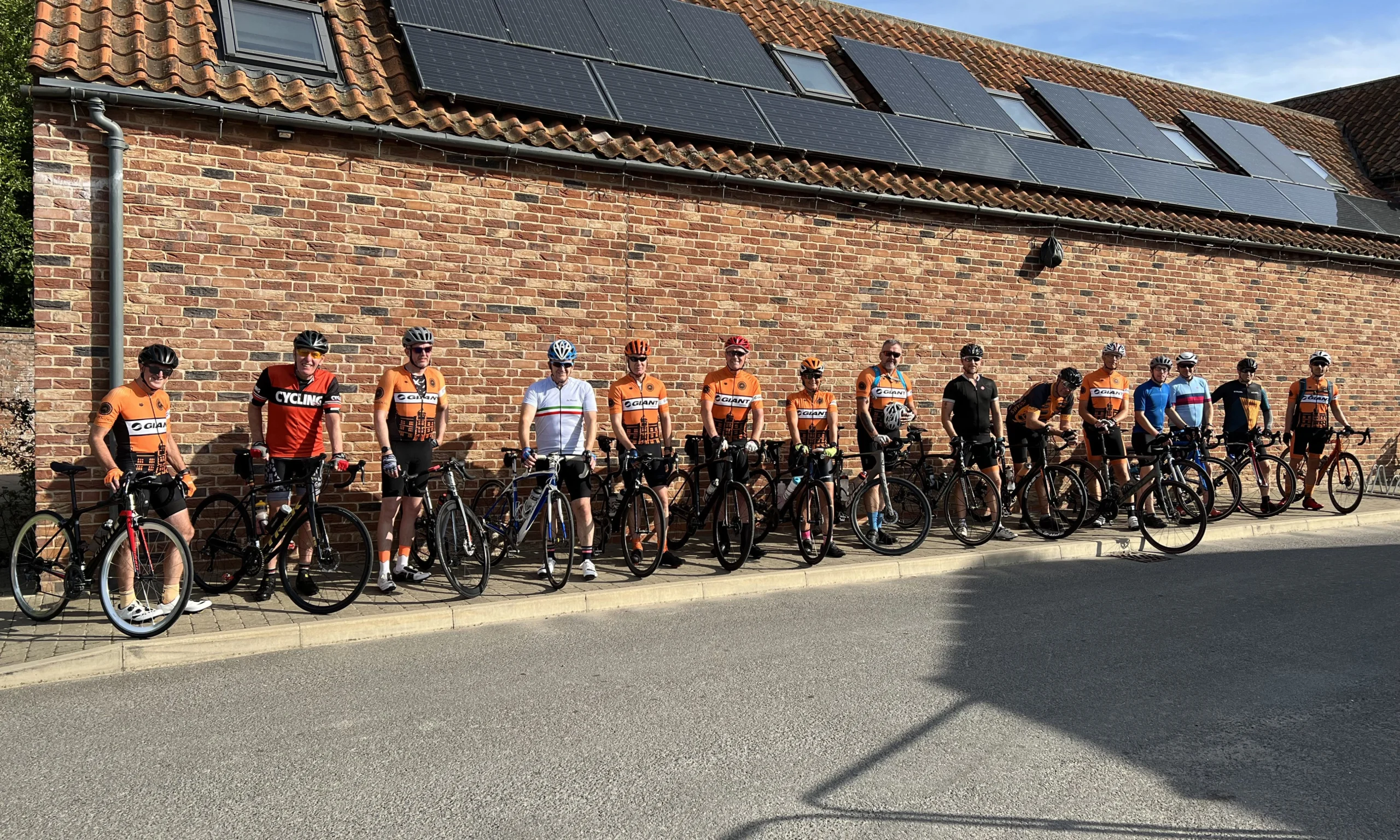 a large group of cyclists stationary opposite grain store doddington hall
