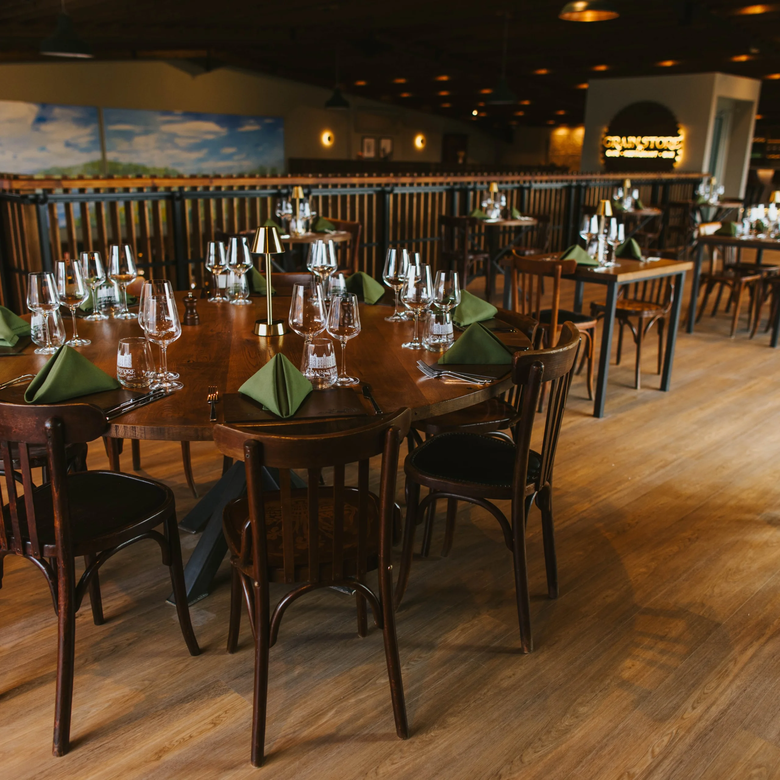 wooden tables setup with glasses and napkins for a supper club at doddington grain store