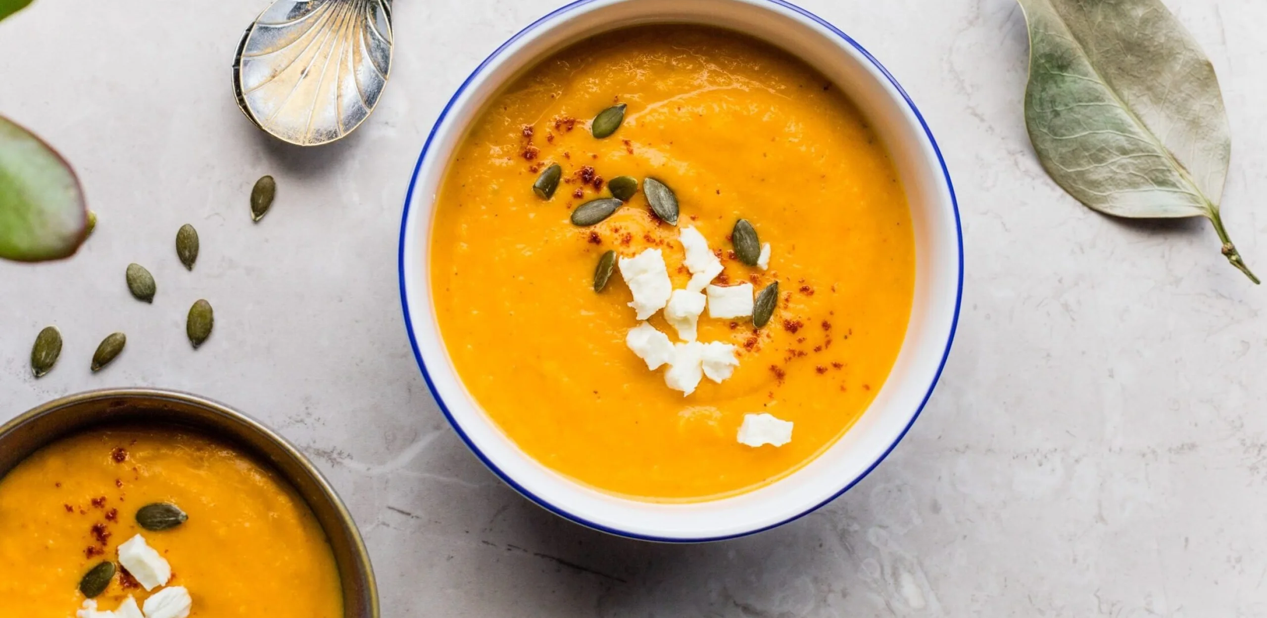 kala soup bowl sprinkled with seeds and cheese on a marble counter top