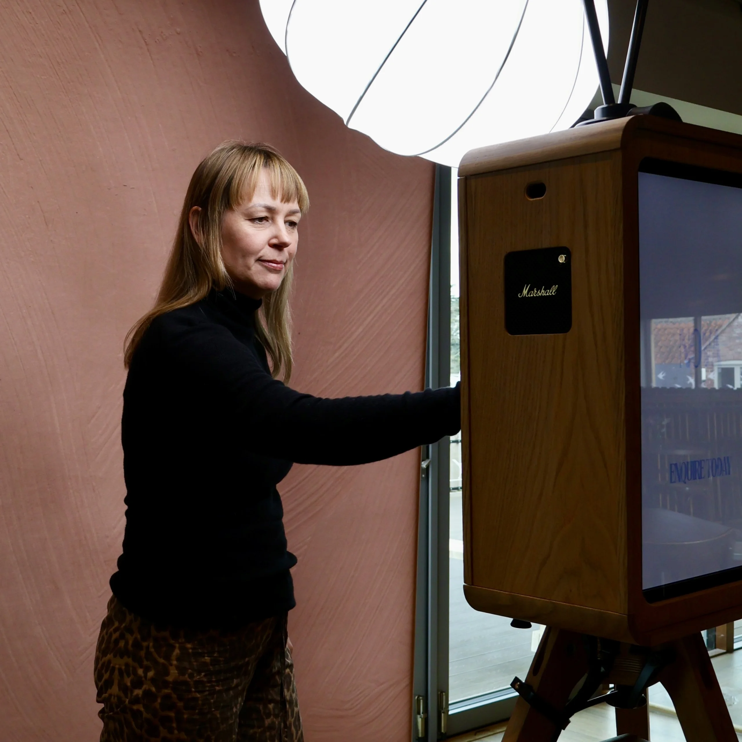 a luxury wedding photo booth setup with light and textured pink backdrop