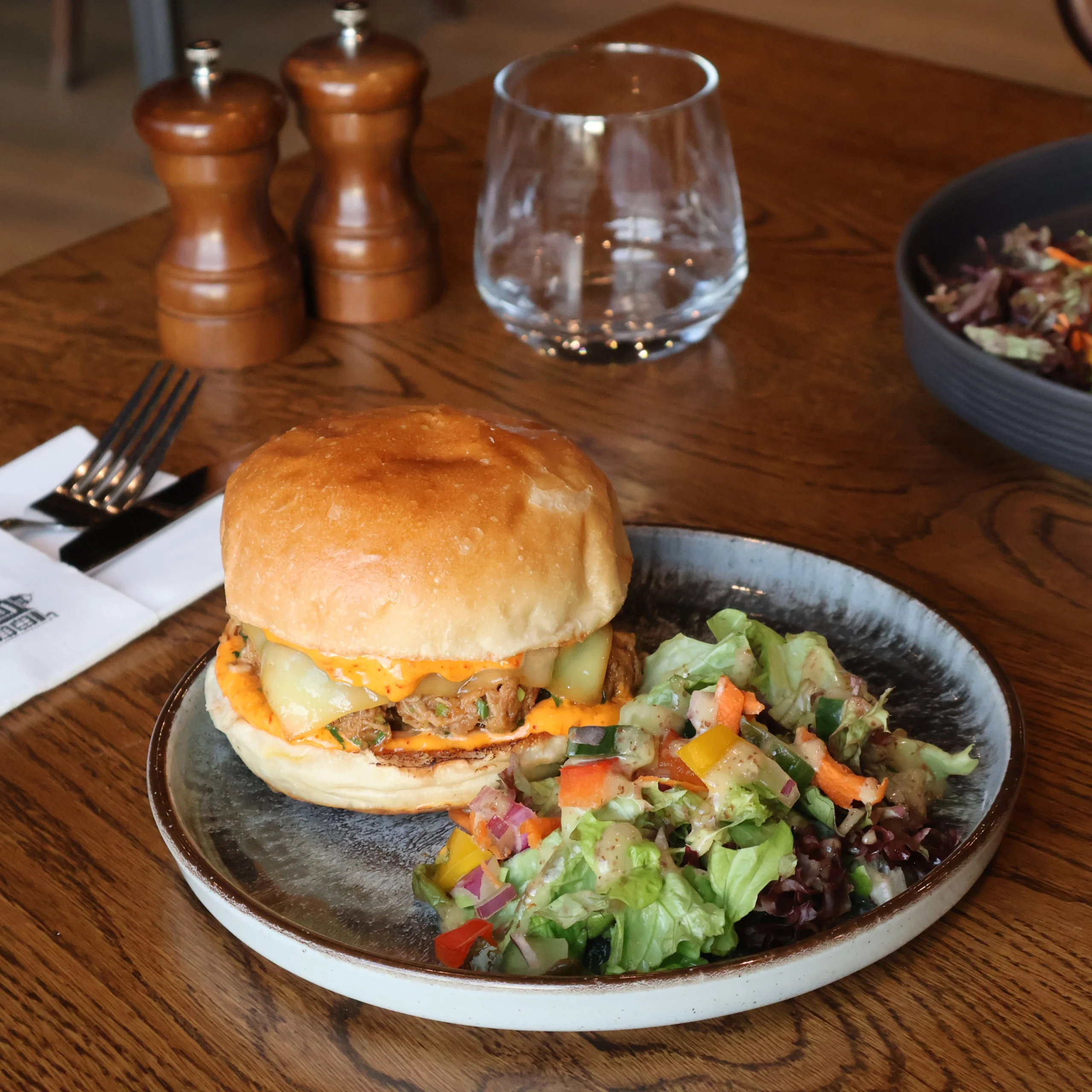 a pulled pork sandwich on a plate with salad at doddington hall grain store