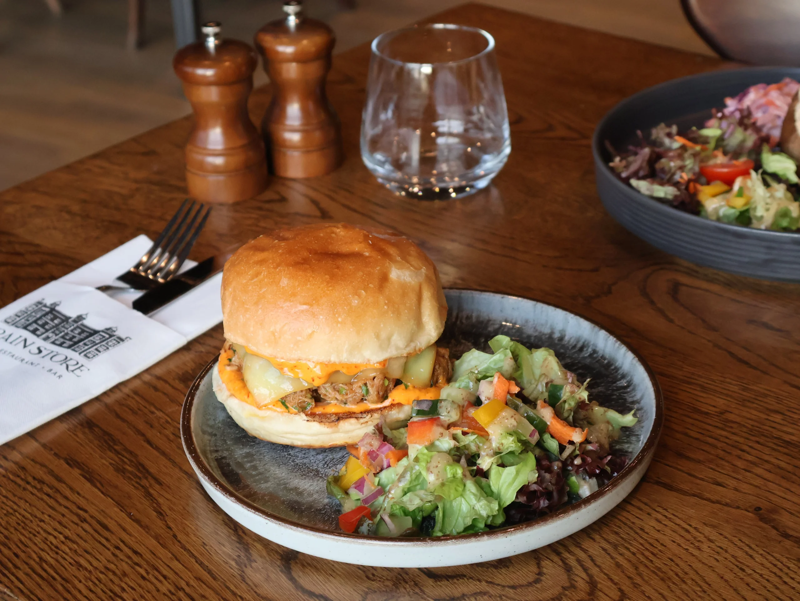 a pulled pork sandwich on a plate with salad at doddington hall grain store