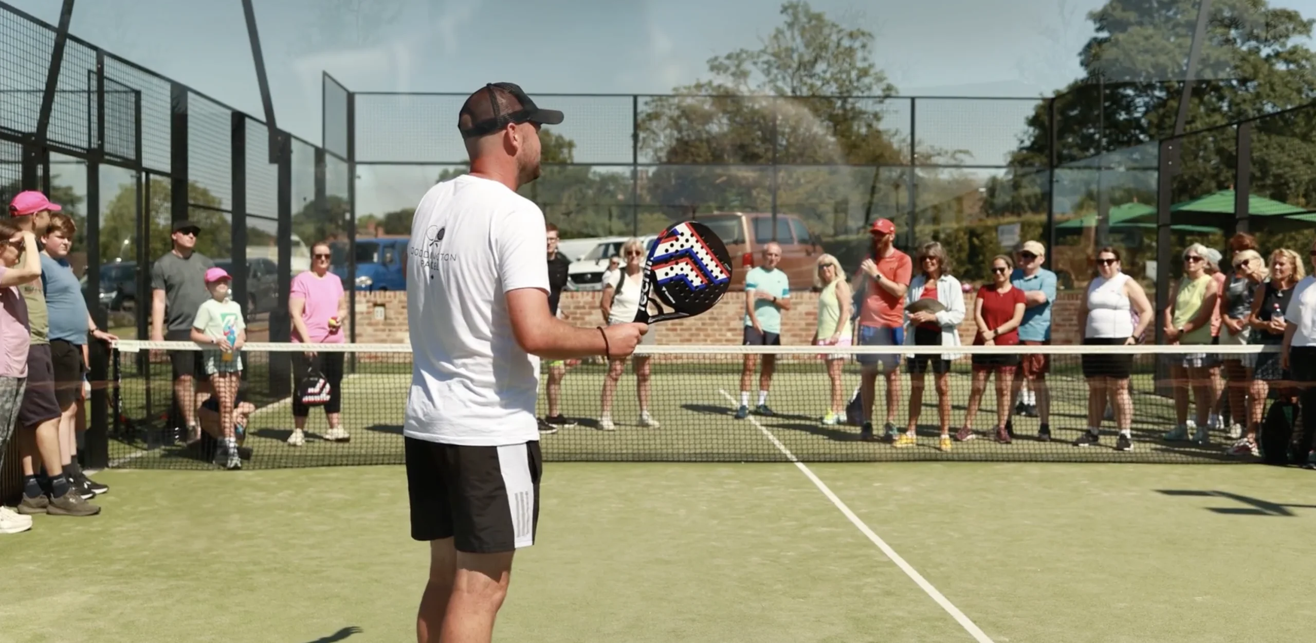 a male padel coach talking to people at doddington hall padel courts