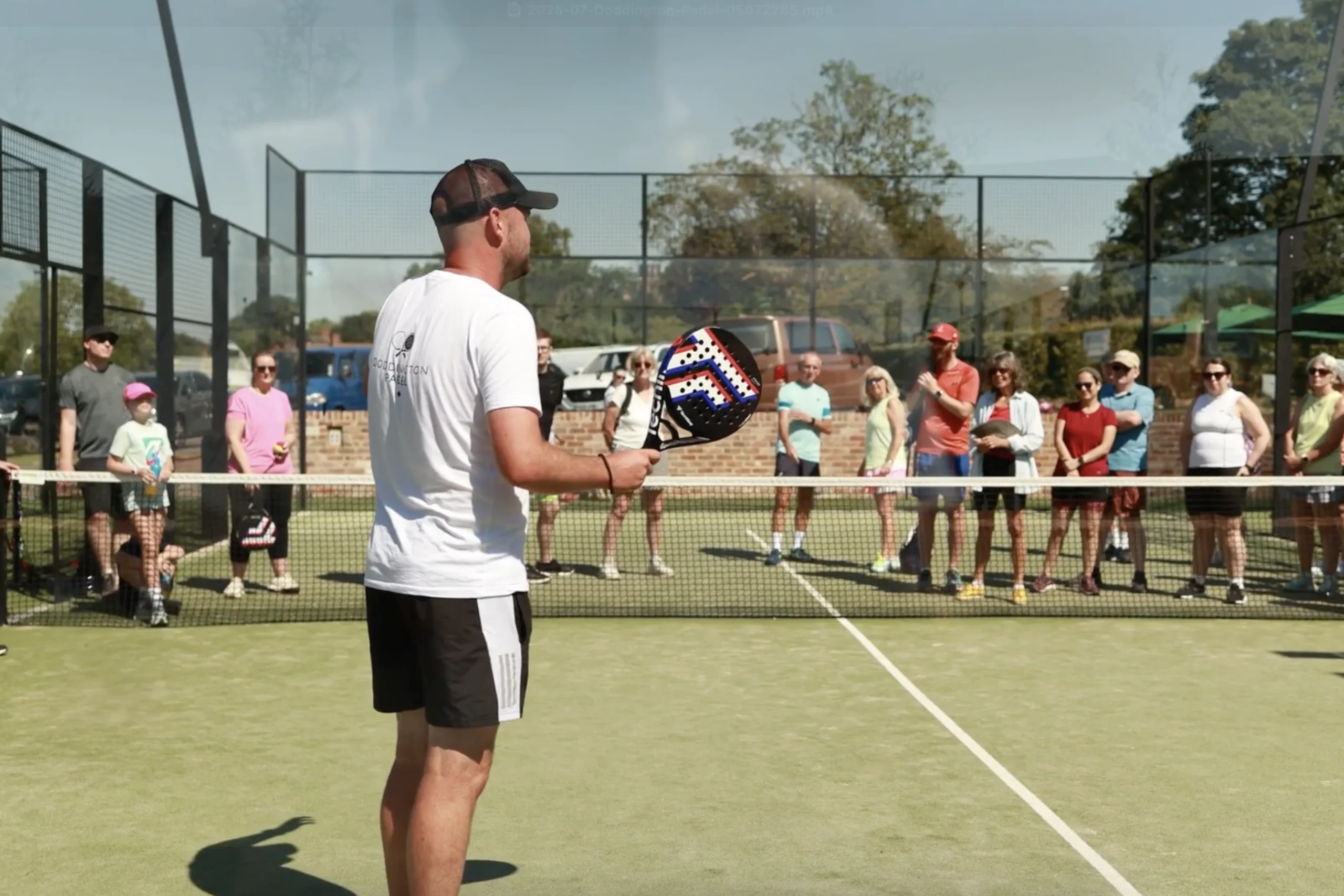 a male padel coach talking to people at doddington hall padel courts