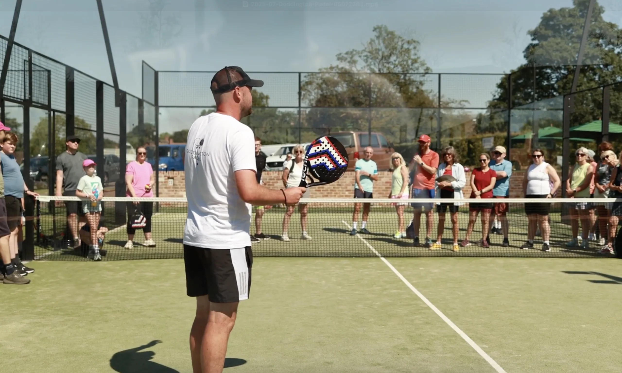 a male padel coach talking to people at doddington hall padel courts