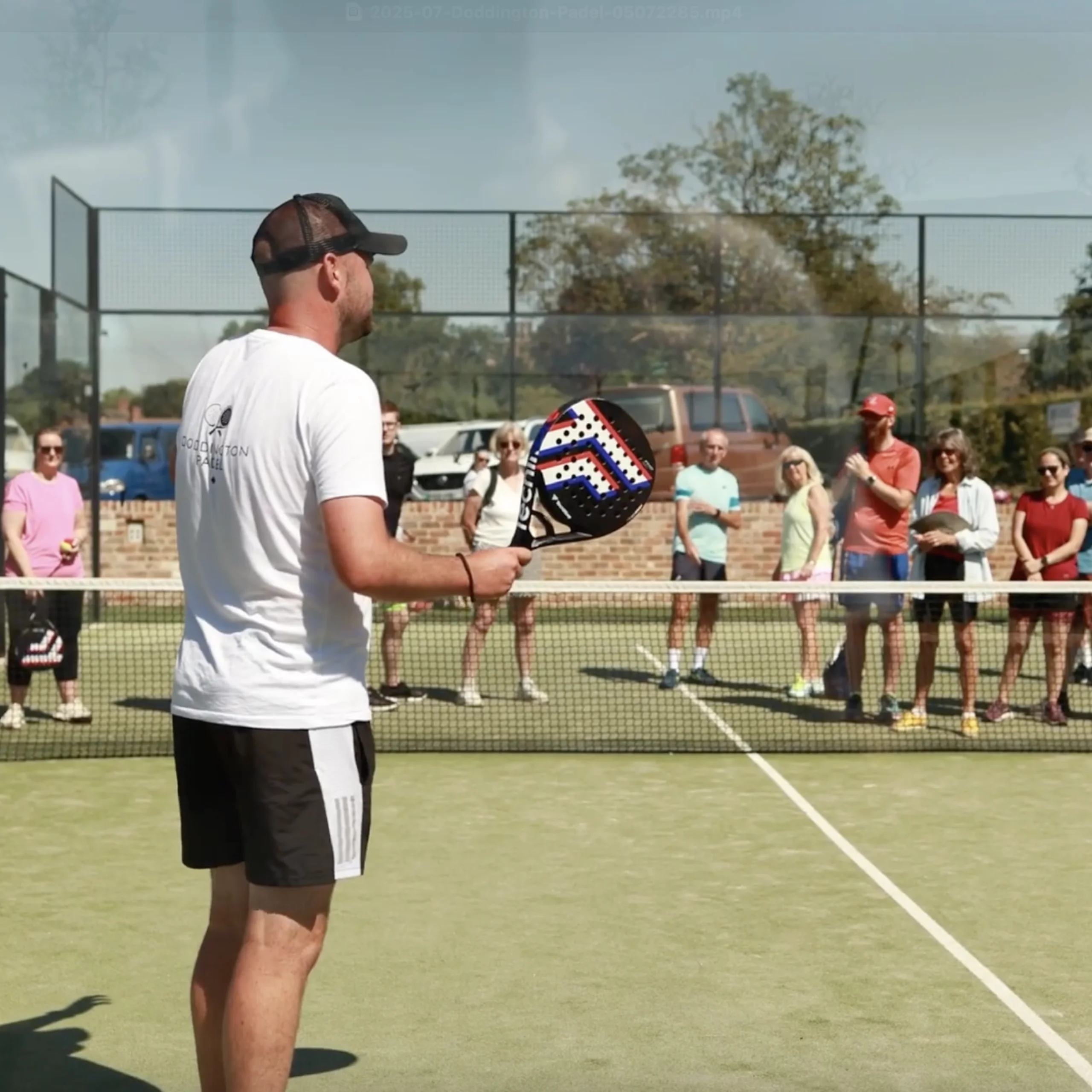 a male padel coach talking to people at doddington hall padel courts