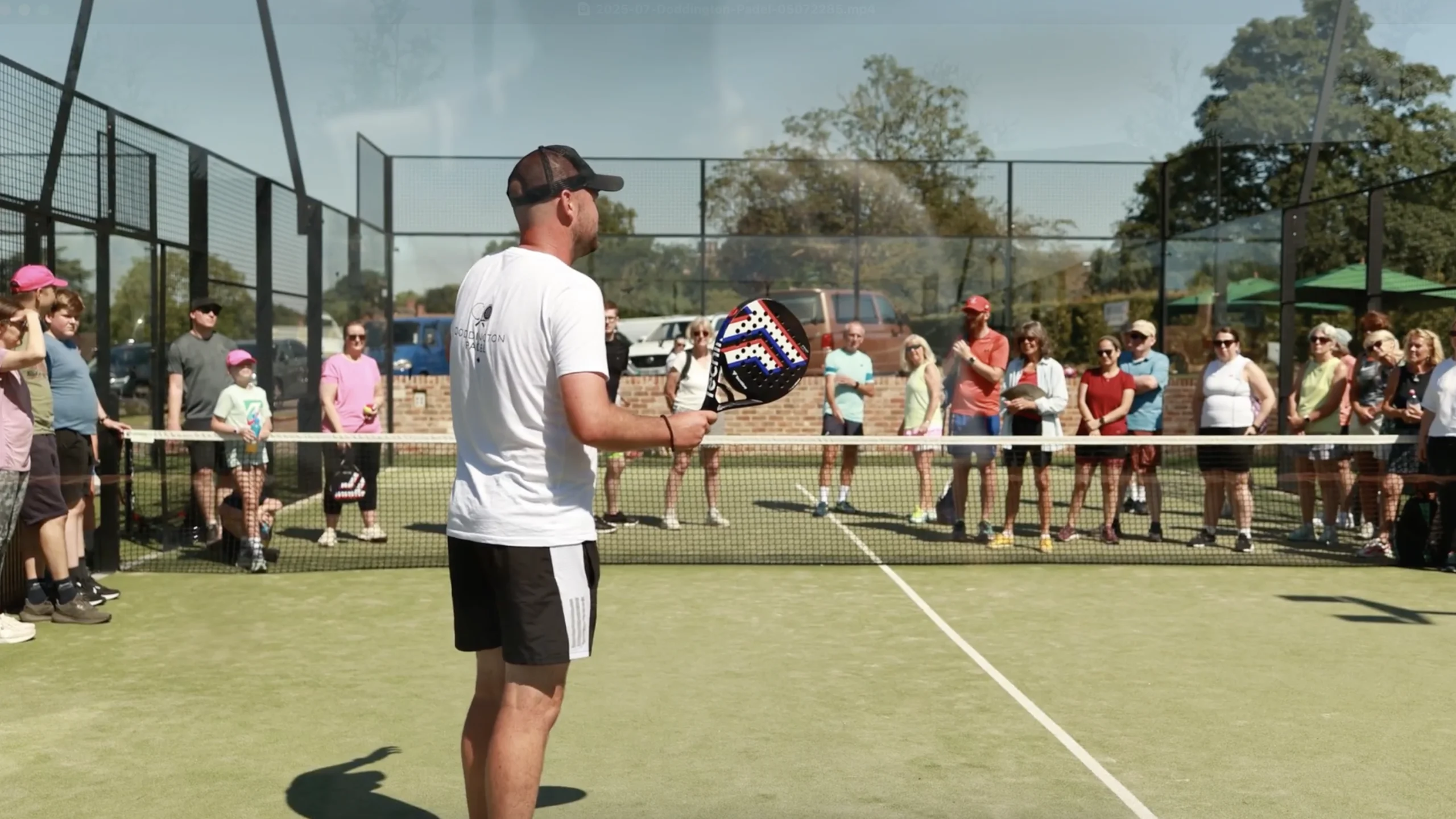 a male padel coach talking to people at doddington hall padel courts