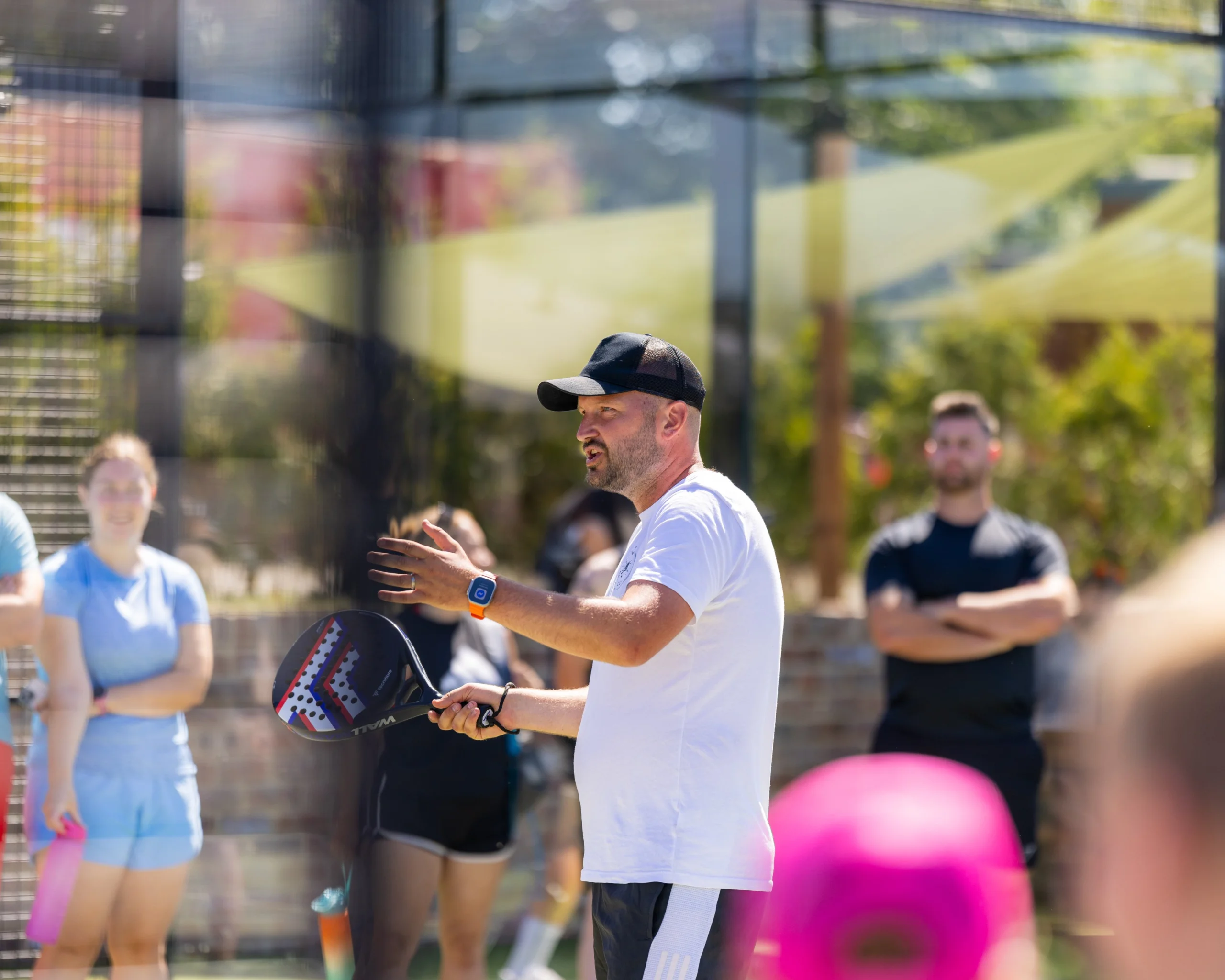 a male padel coach talking to people at doddington hall padel courts