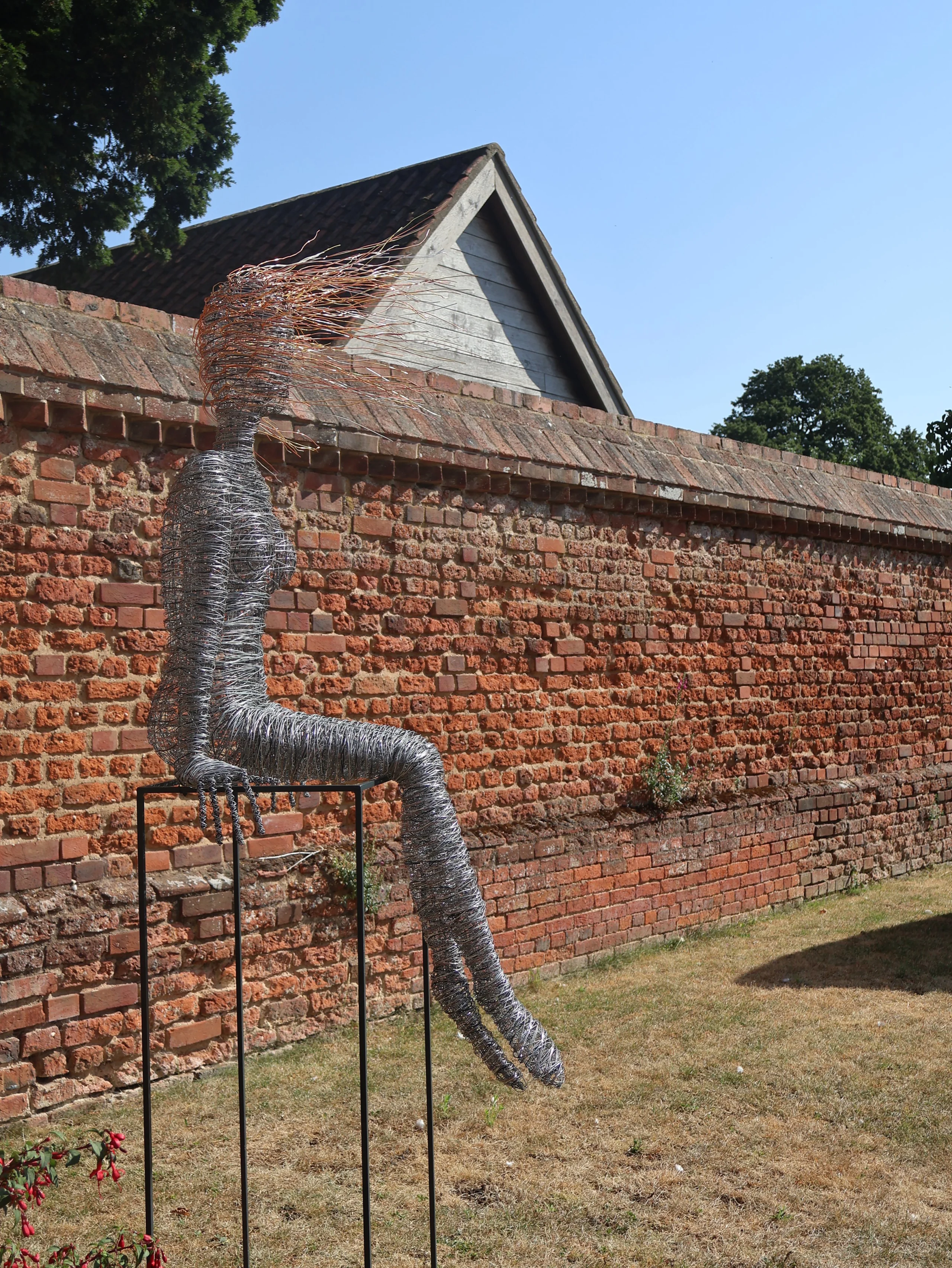 a wire woman sculpture in the ground of doddington hall