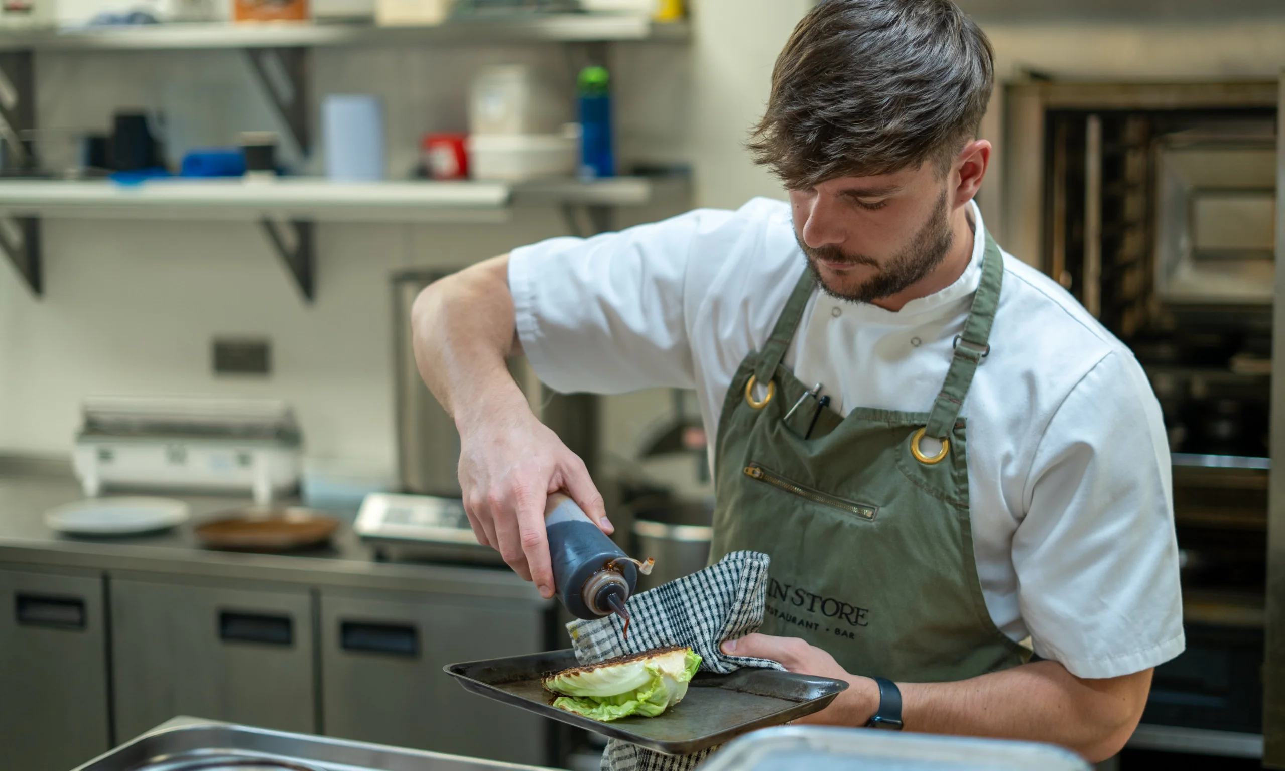 a chef preparing hispi cabbage at doddington hall grain store restaurant