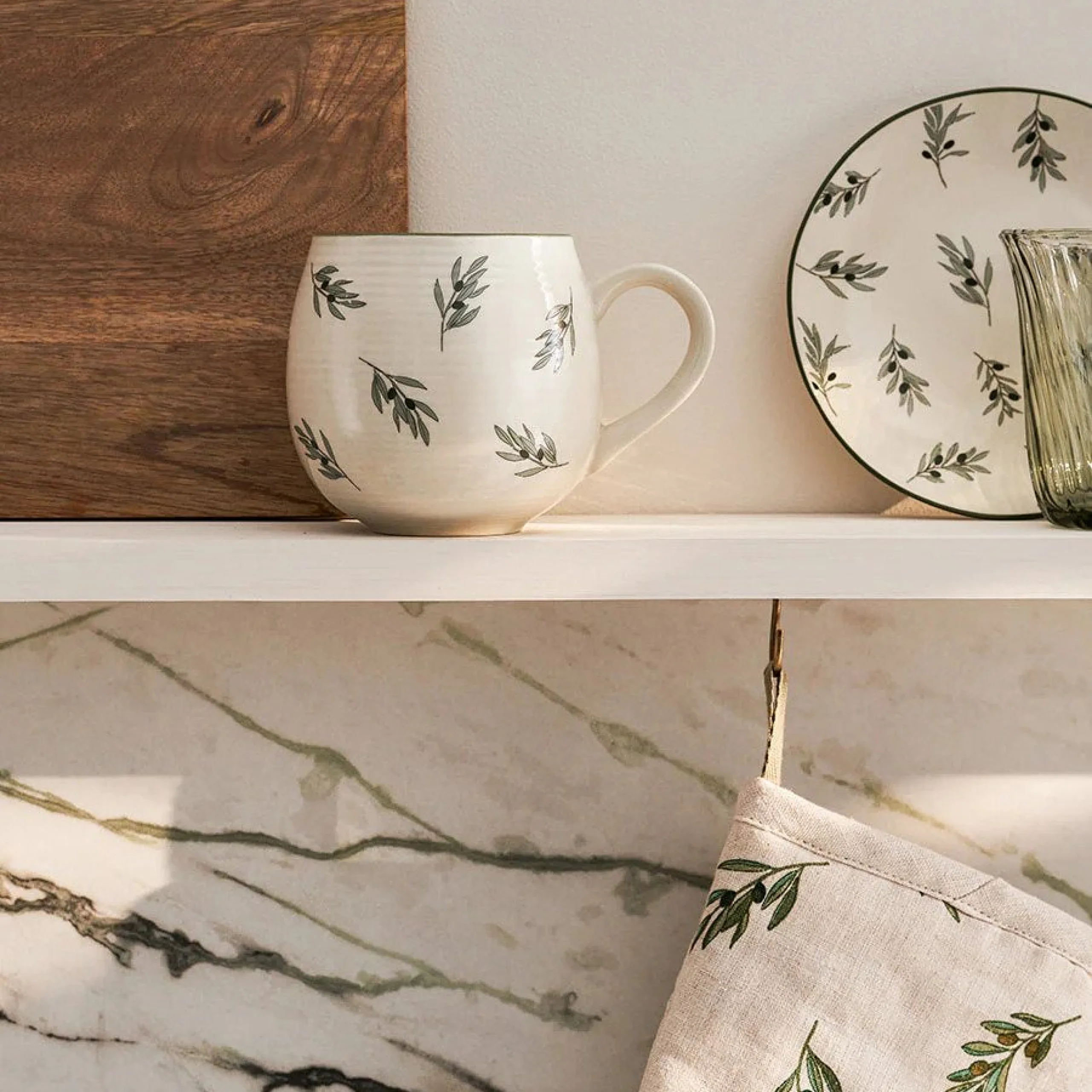 a mug and plate styled on a white shelf for the home store at doddington hall