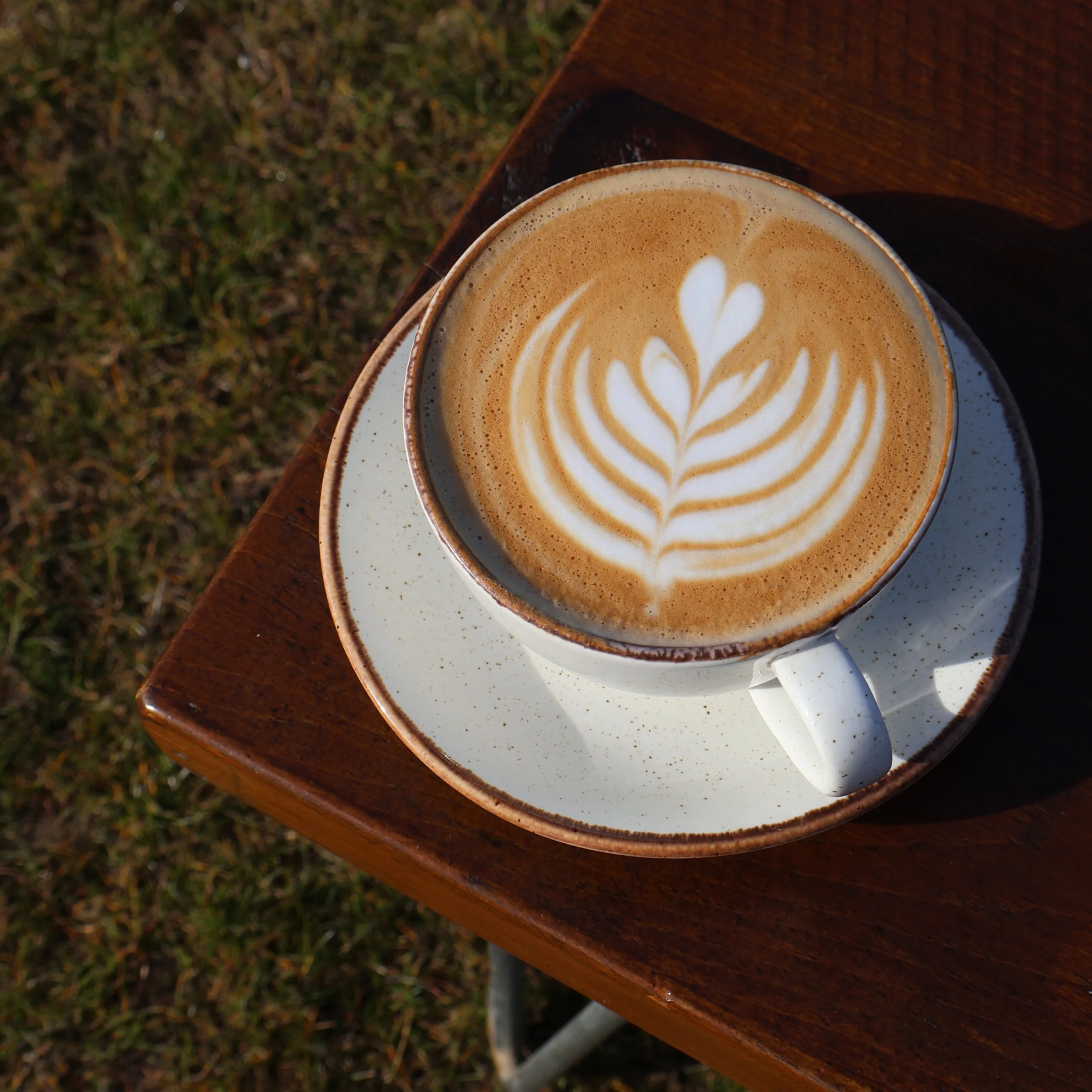 a close up of a latte with coffee art at doddington hall