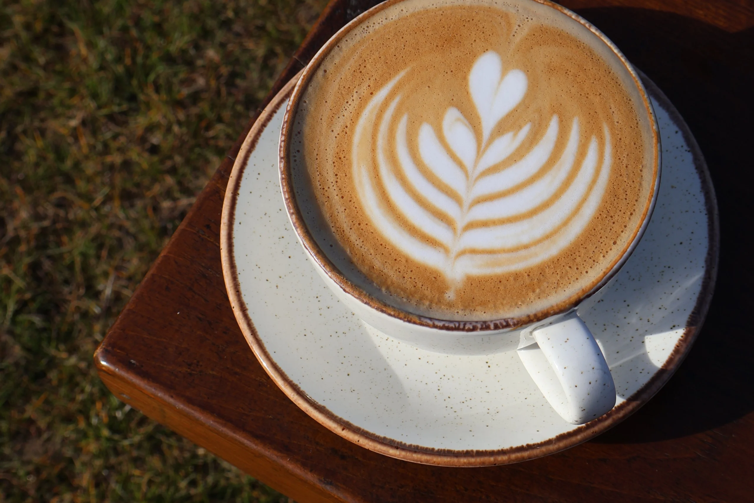 a close up of a latte with coffee art at doddington hall