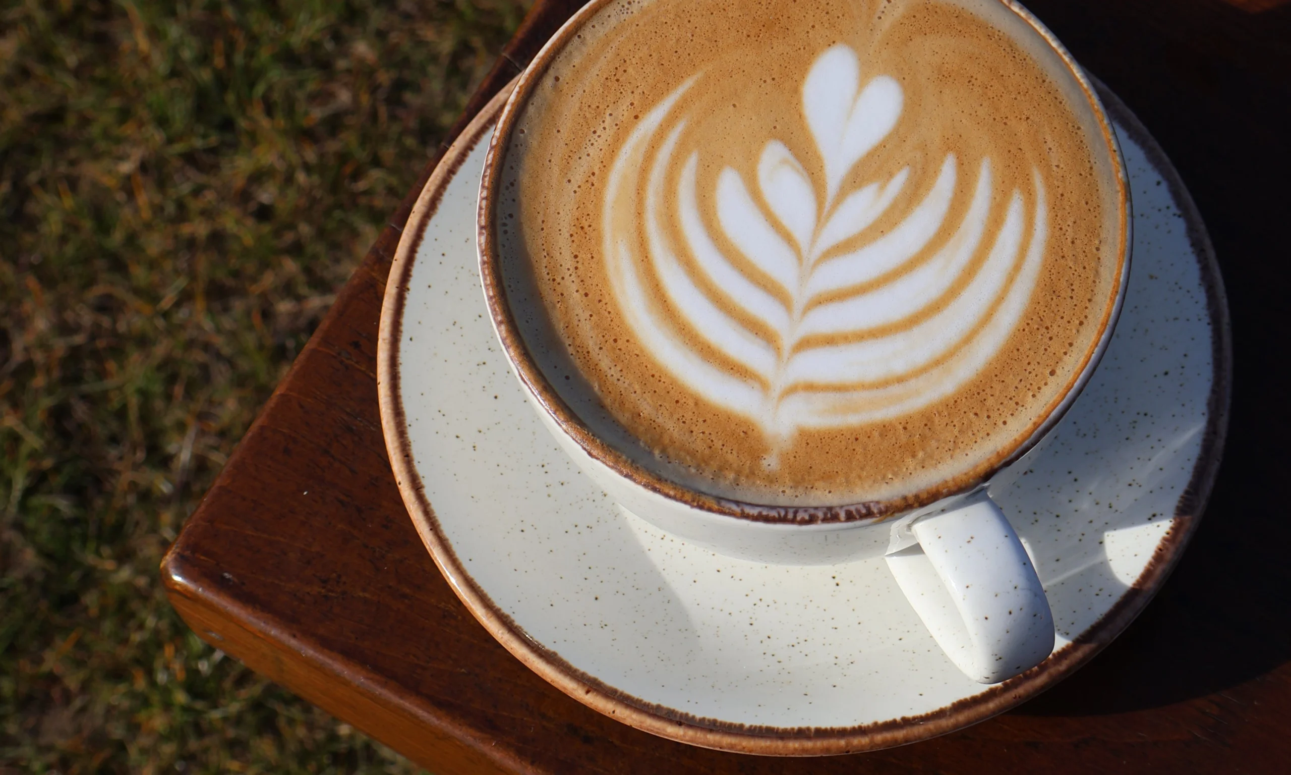a close up of a latte with coffee art at doddington hall