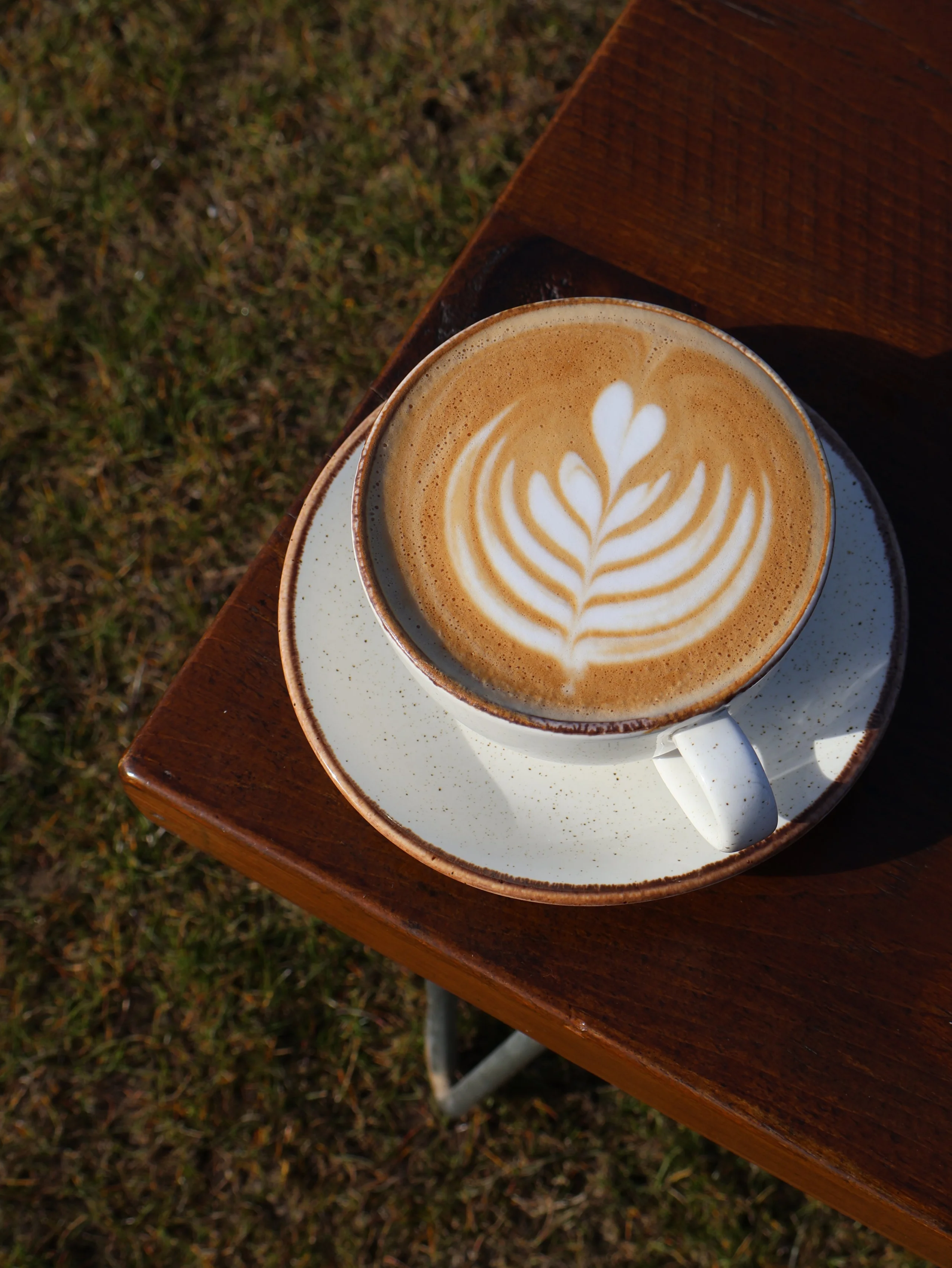 a close up of a latte with coffee art at doddington hall