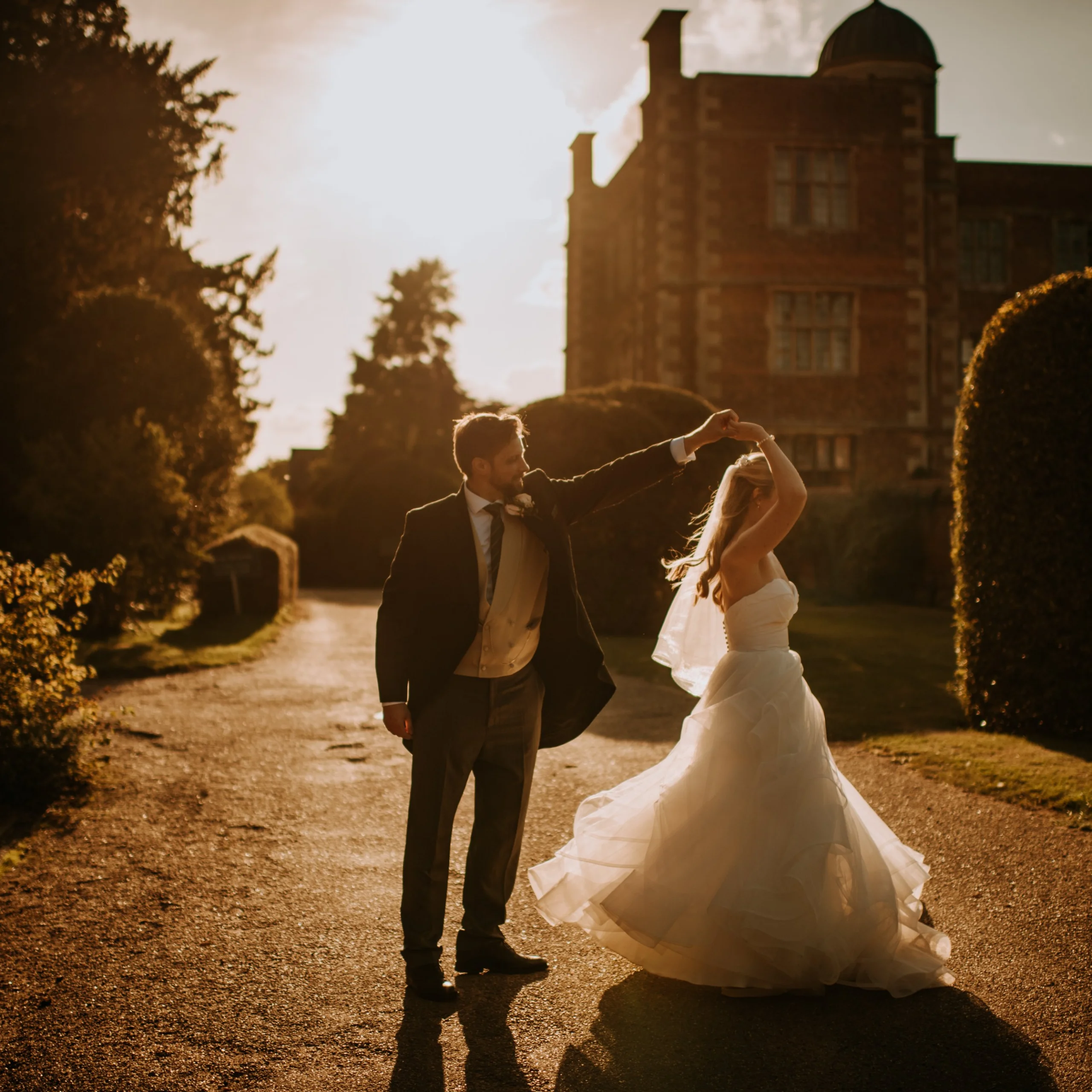 a bride and groom dancing in sunset lighting in the garden at doddington hall