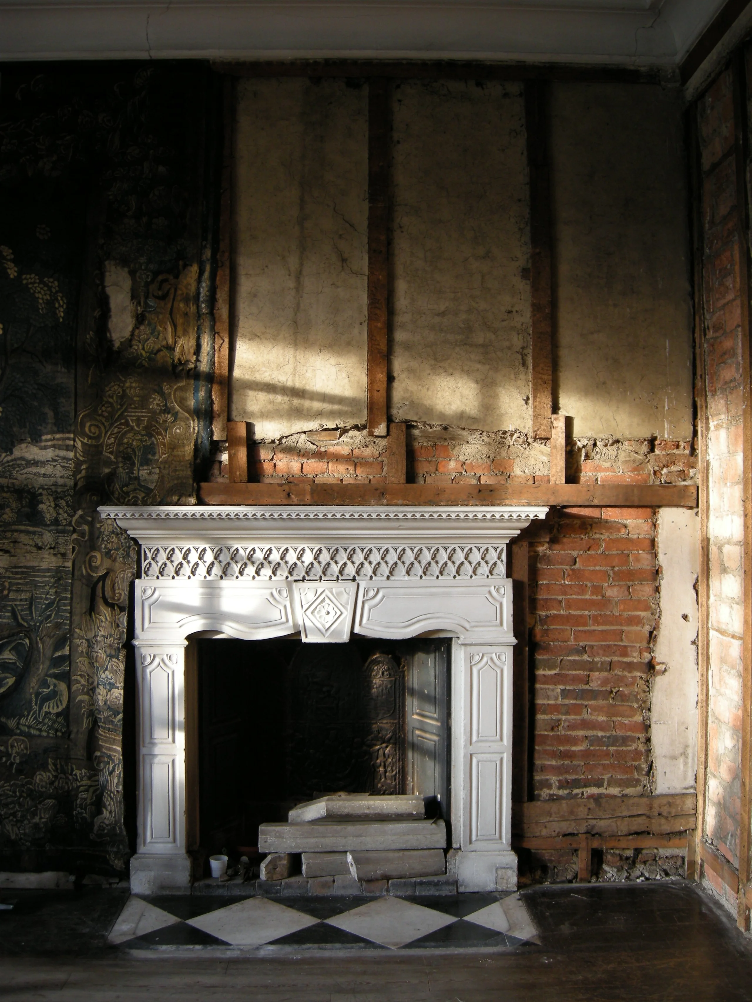 an old fireplace with a white surround at doddington hall