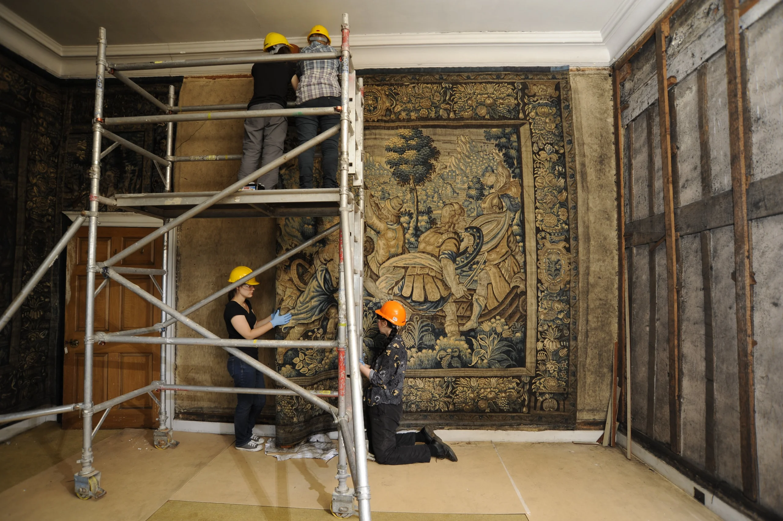 conservation artists hanging a tapestry at doddington hall