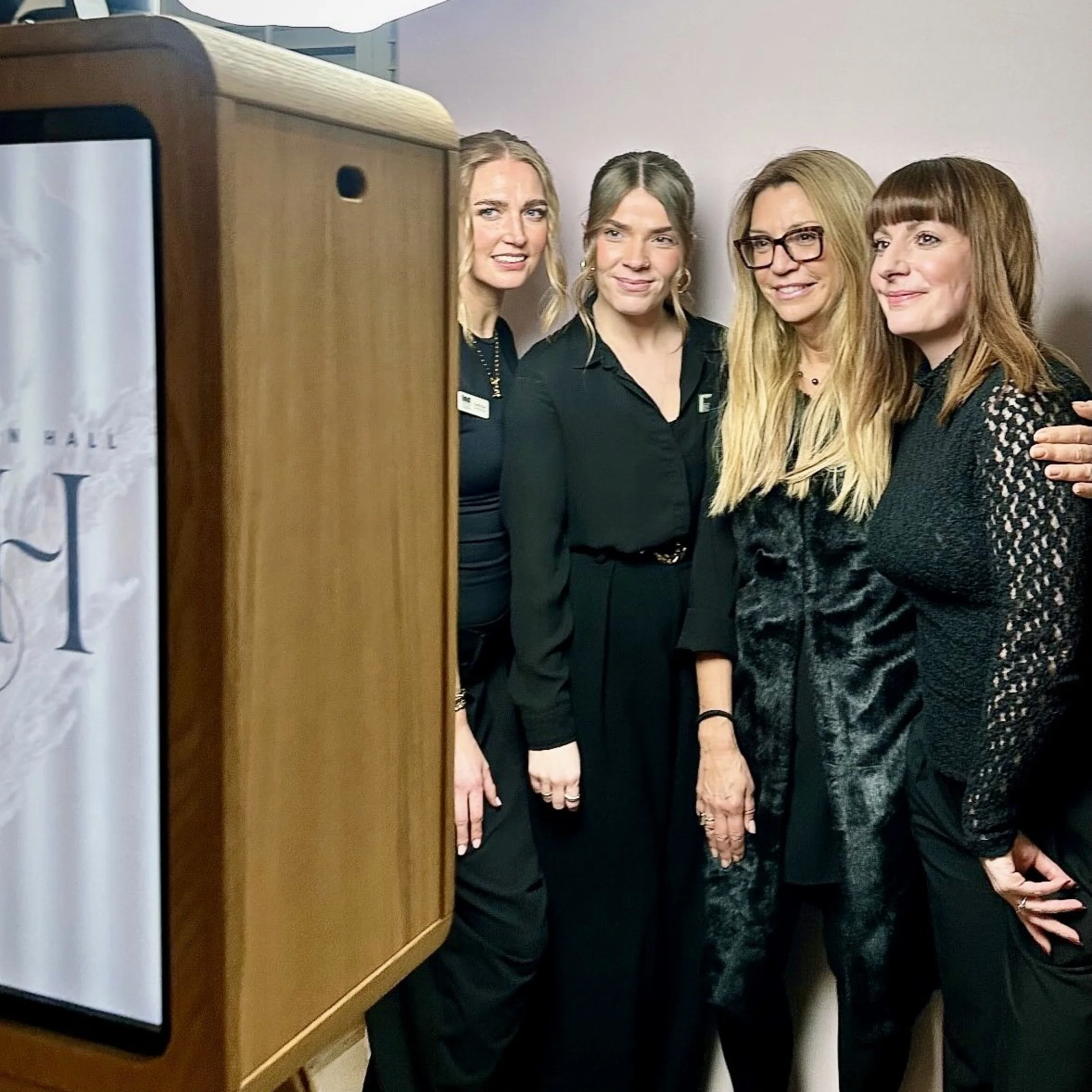 four women dressed in black at a team event