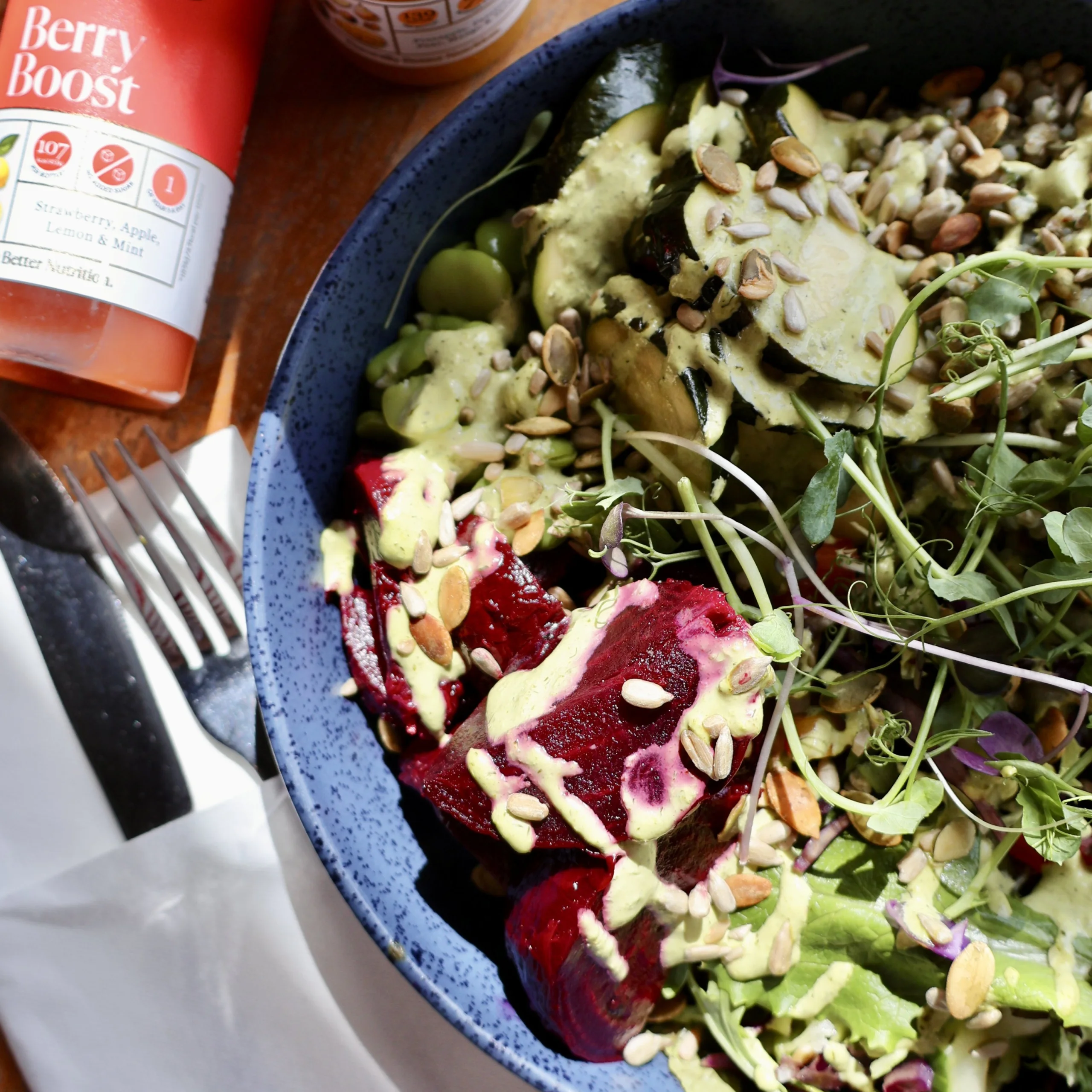 wellness bowl of food on a table with fresh juice bottles