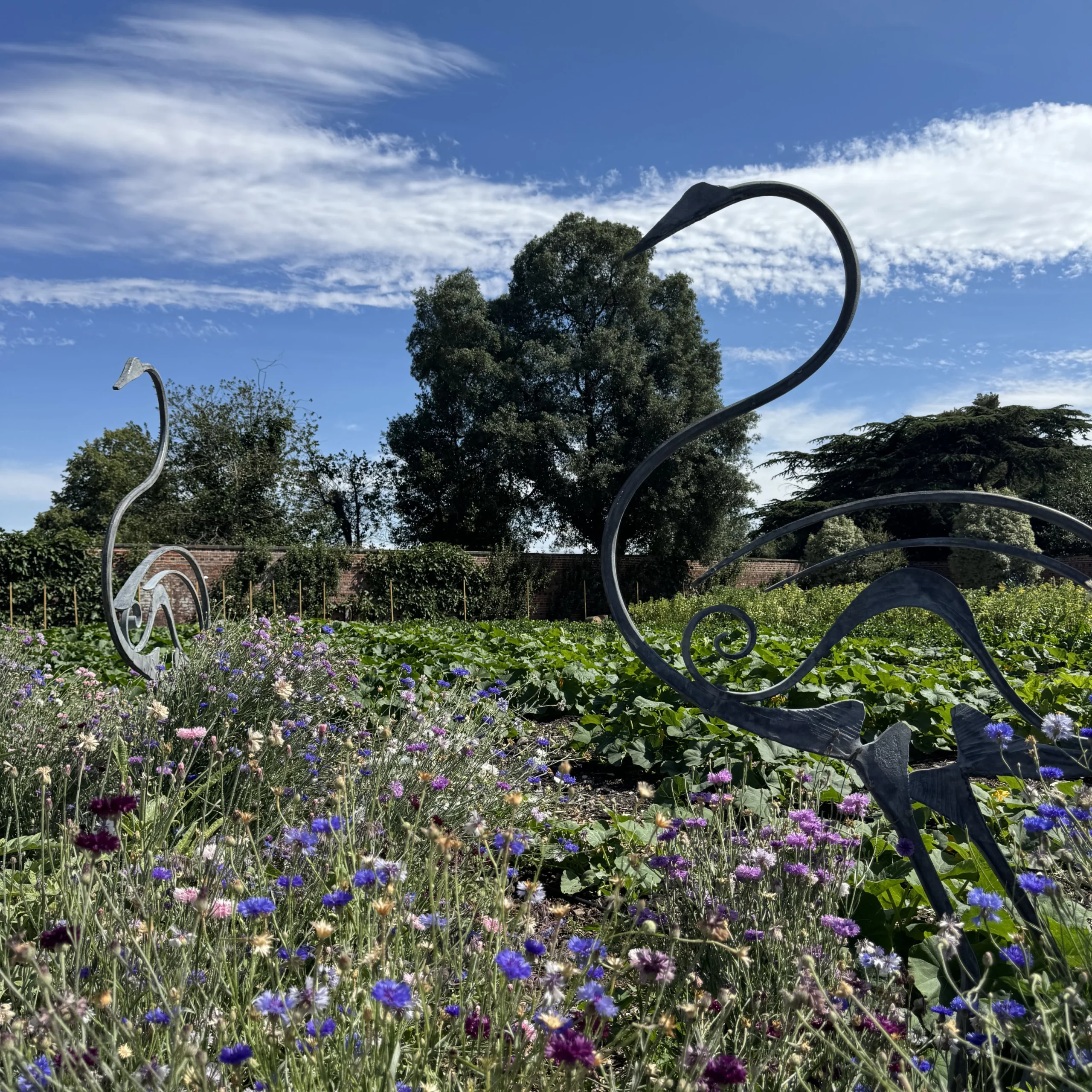 bird sculptures in a field of wildflowers